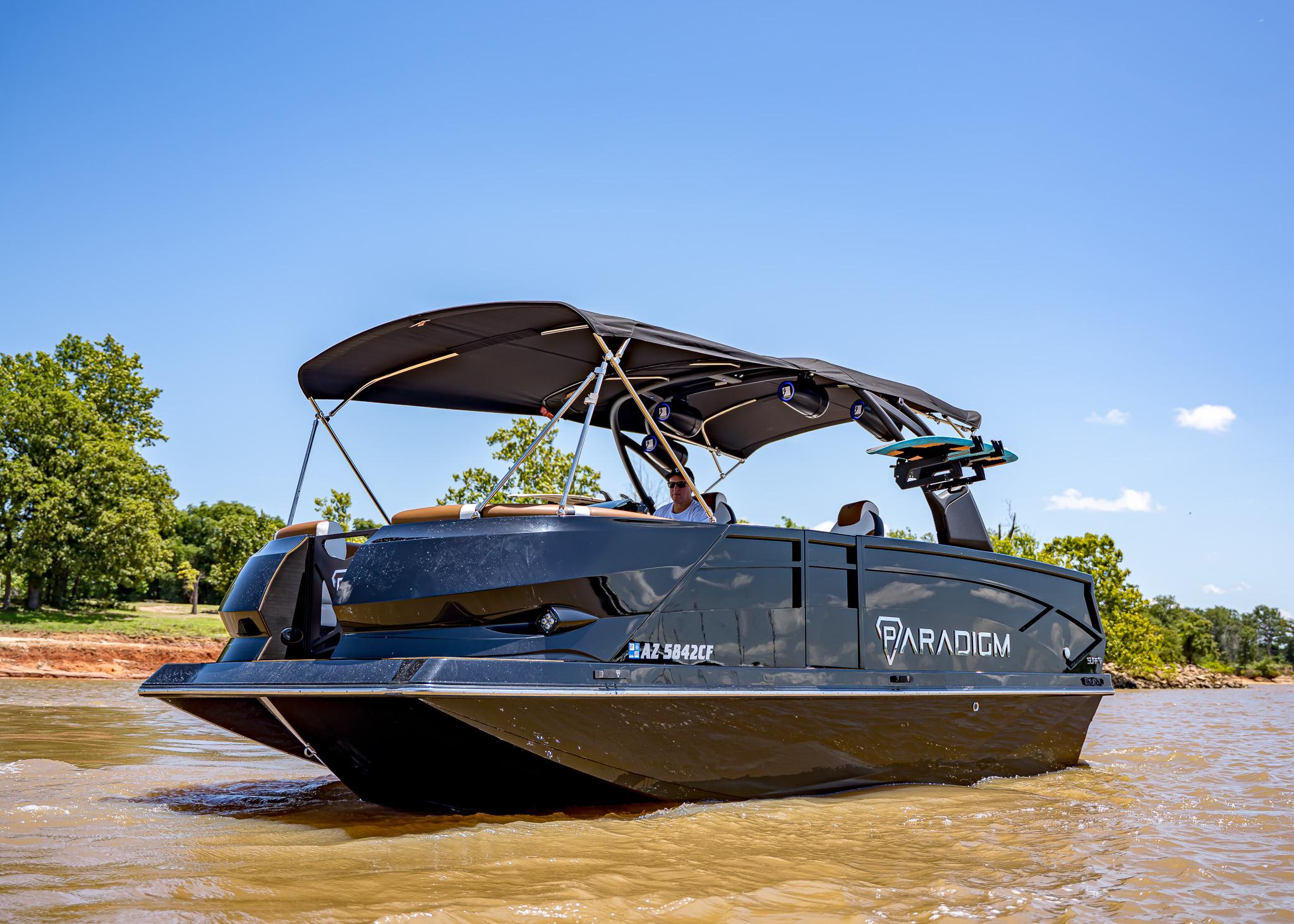 2025 Paradigm 236 boat cruising on a sunny day, featuring sleek design and canopy.