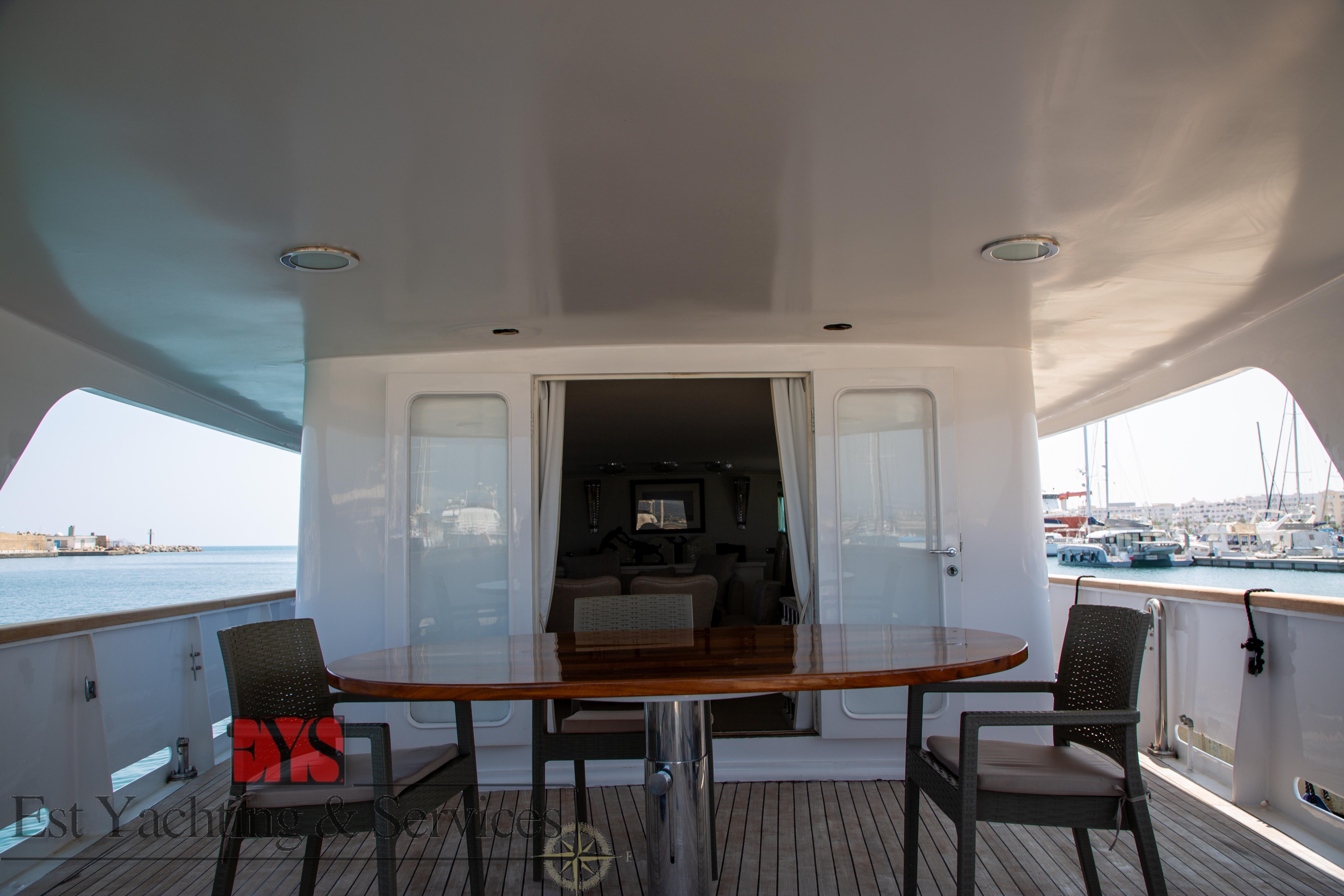 Deck view of 1972 Benetti 33 yacht with table and chairs, overlooking marina.