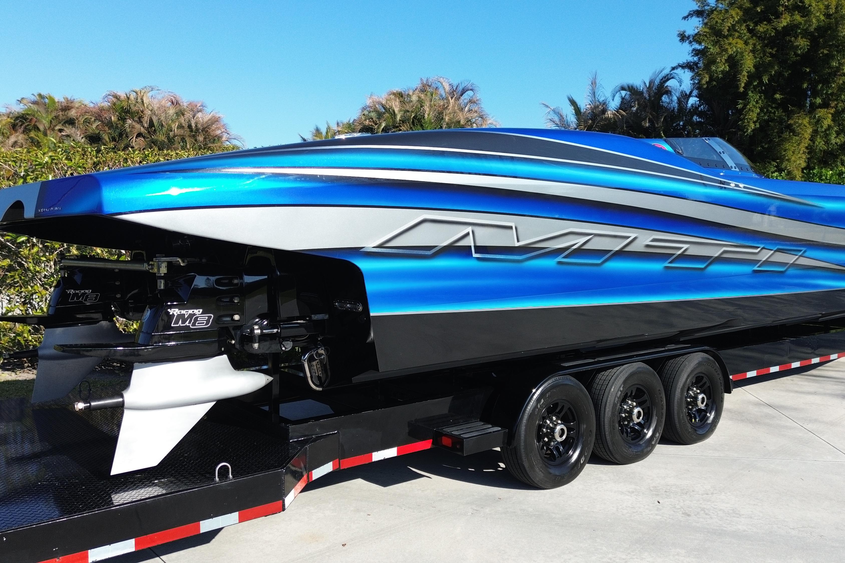 2016 MTI 44 RP powerboat with vibrant blue and silver design on a trailer.