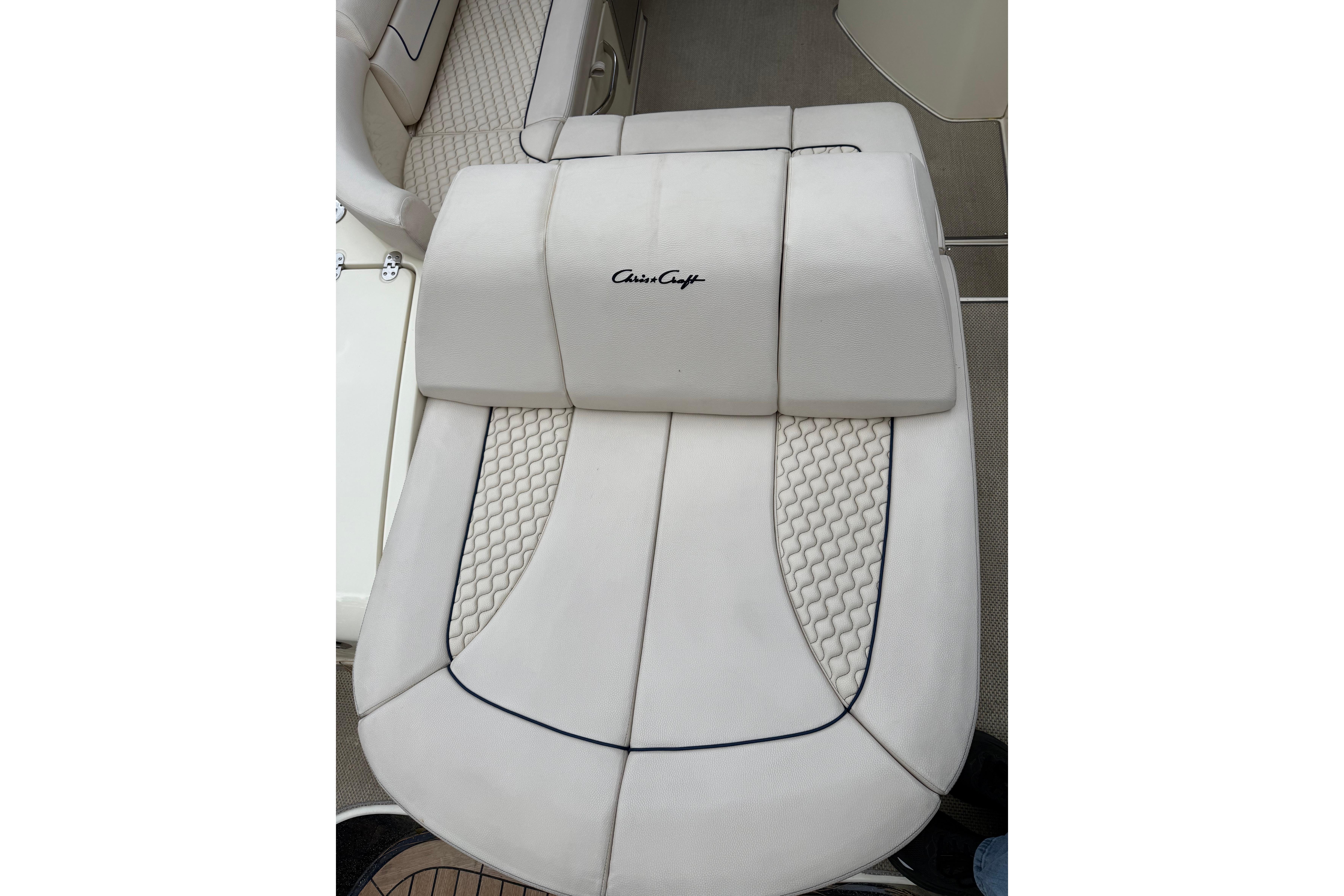 2019 Chris-Craft Launch 28 GT boat seat with elegant white upholstery and logo detailing.