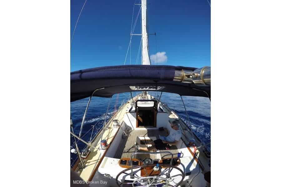 Sailing on a 1964 Stephen Marine Sparkman & Stephens 73 yacht under clear blue skies.