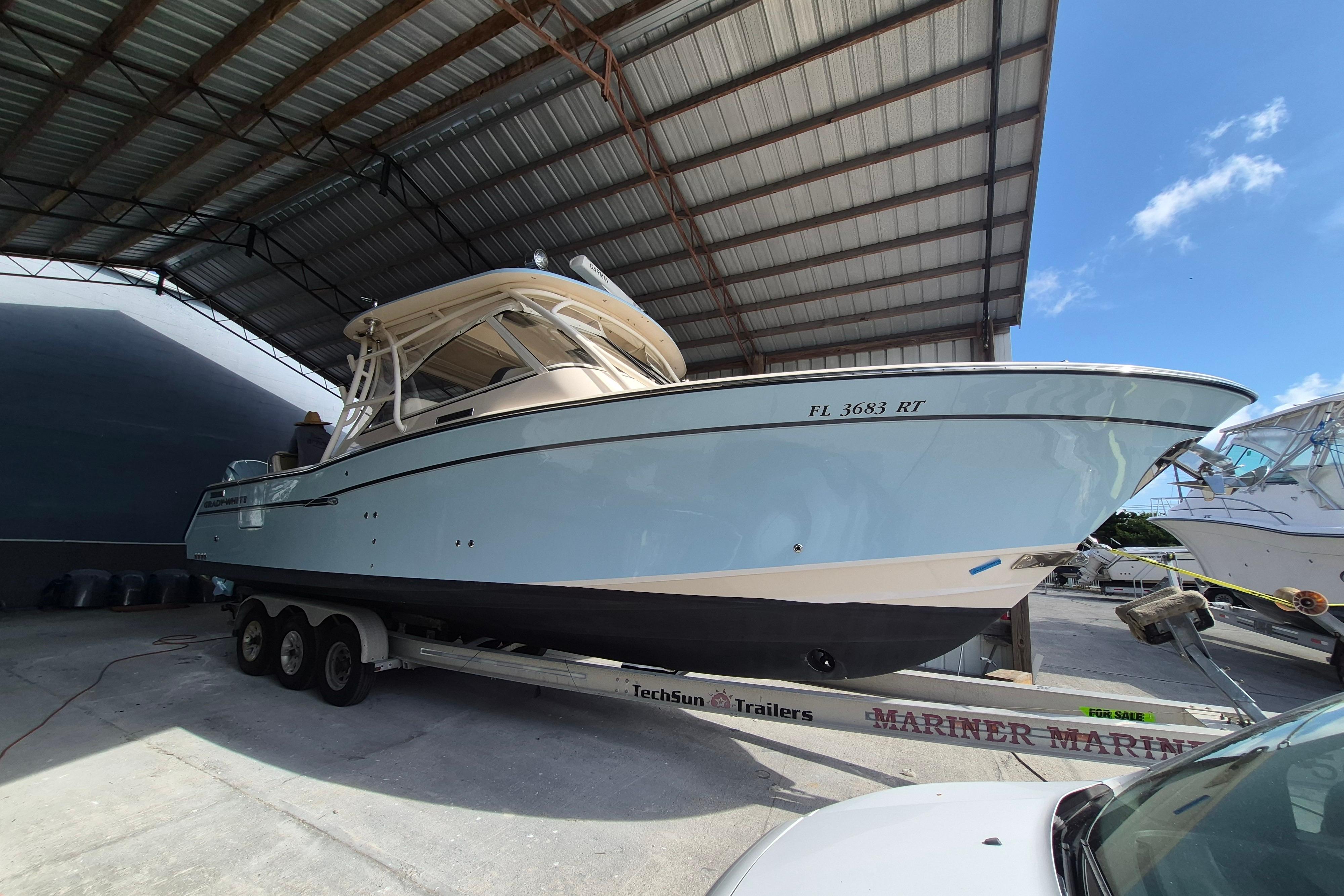 2019 Grady-White Freedom 335 boat on trailer under shelter, side view.