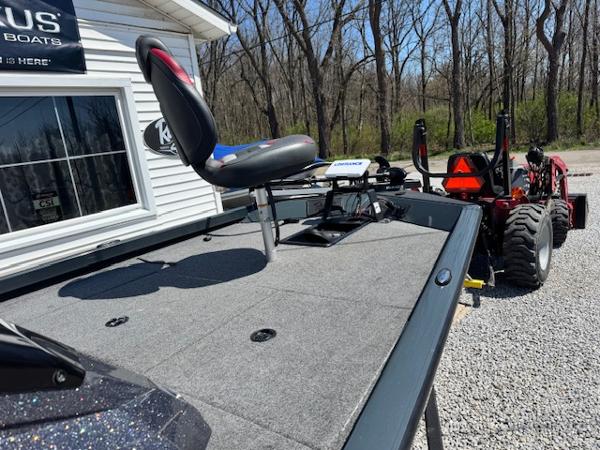 2023 Ranger RT178 boat with elevated seat, parked near a building, surrounded by trees.