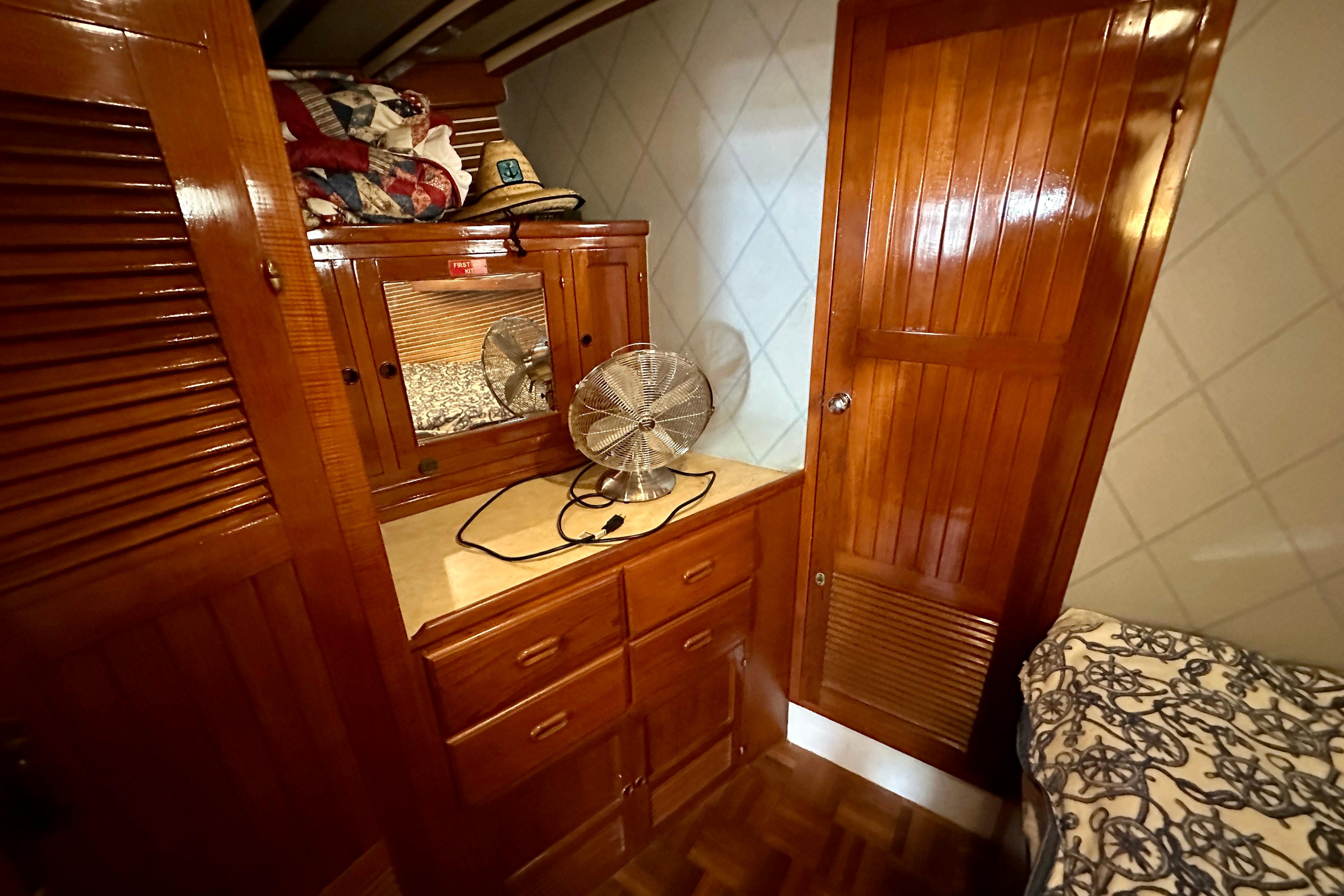 1983 Kadey-Krogen Krogen 42 Trawler cabin with wooden cabinetry and fan.
