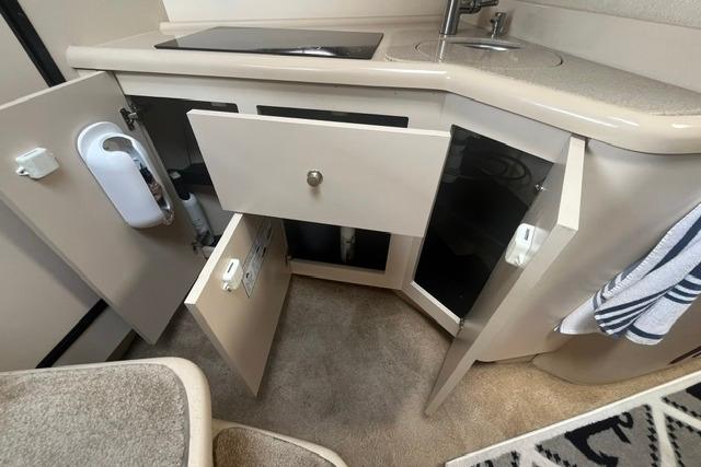 2004 Cruisers Yachts 3372 Express interior kitchen with open cabinets and sink.