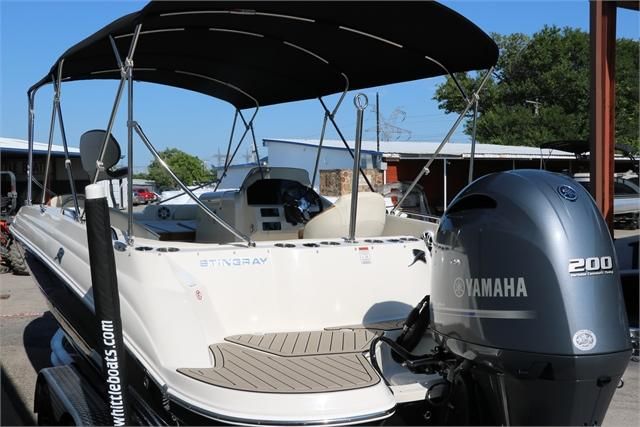 A 2022 Stingray 212 SC boat with a Yamaha 200 engine, parked in a marina area.