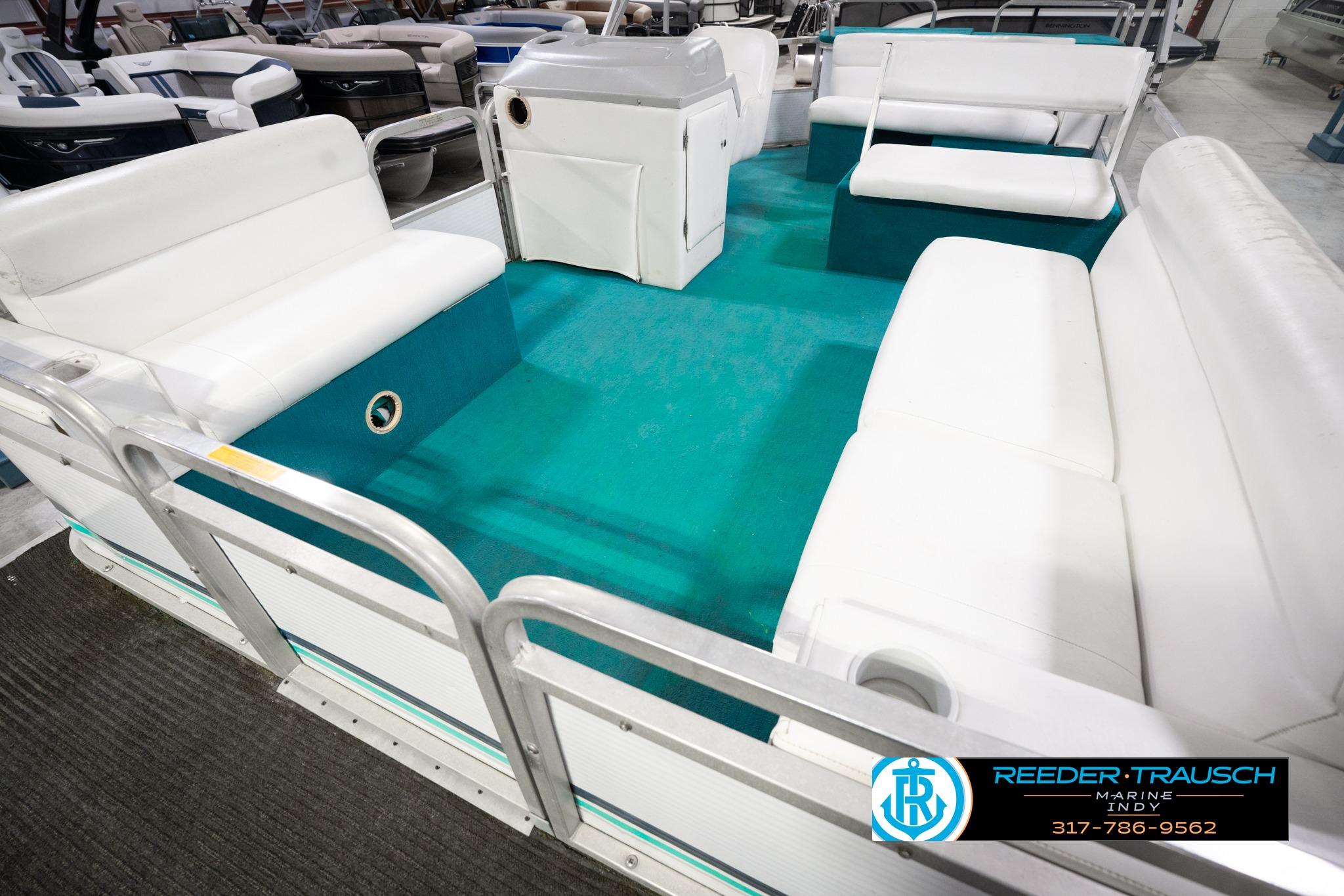 1992 Godfrey Sweetwater pontoon boat interior with white seating and teal flooring.