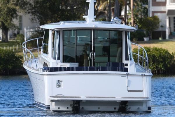 2025 Sabre 43 Salon Express yacht on calm water, rear view.