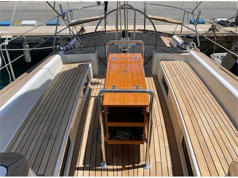 Spacious deck of 2014 Belliure 50 yacht with wooden seating and table.