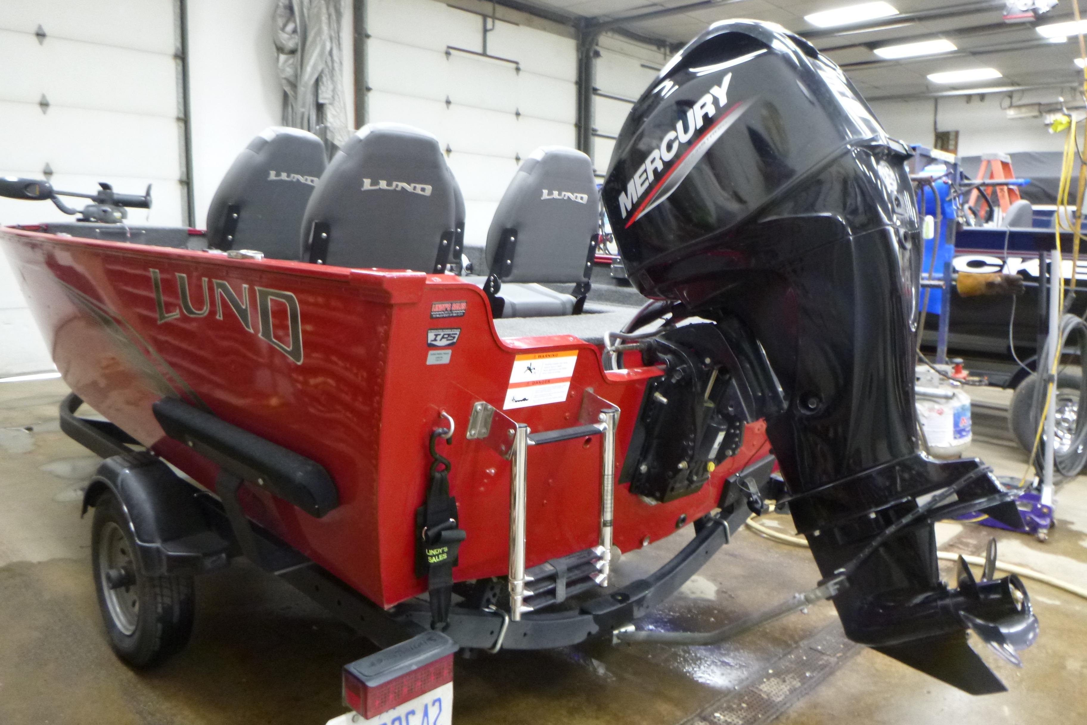 2022 Lund 1650 Angler Sport boat with Mercury outboard motor in a garage.
