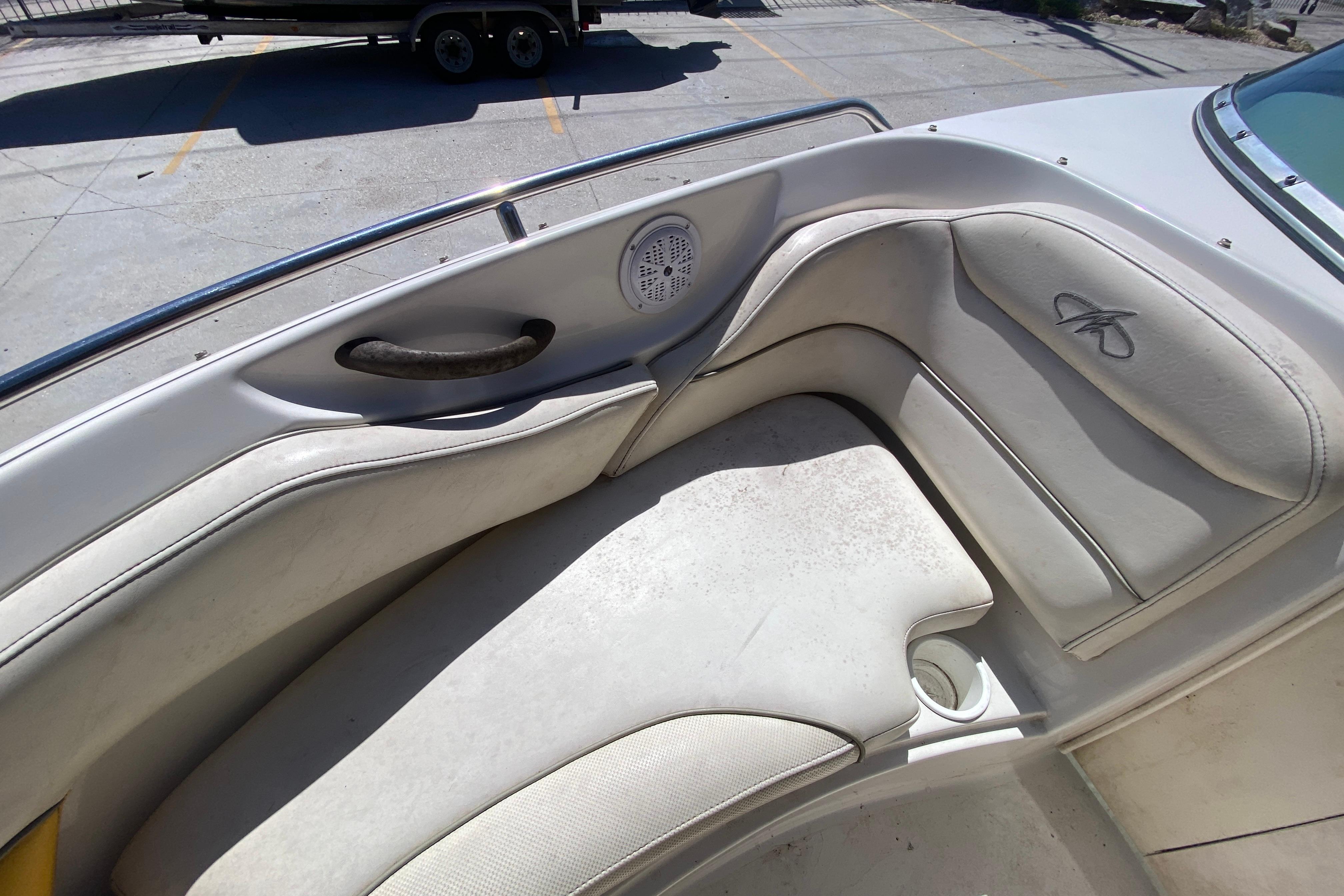 2003 Monterey 208SI Montura boat interior with white cushioned seating and speaker.