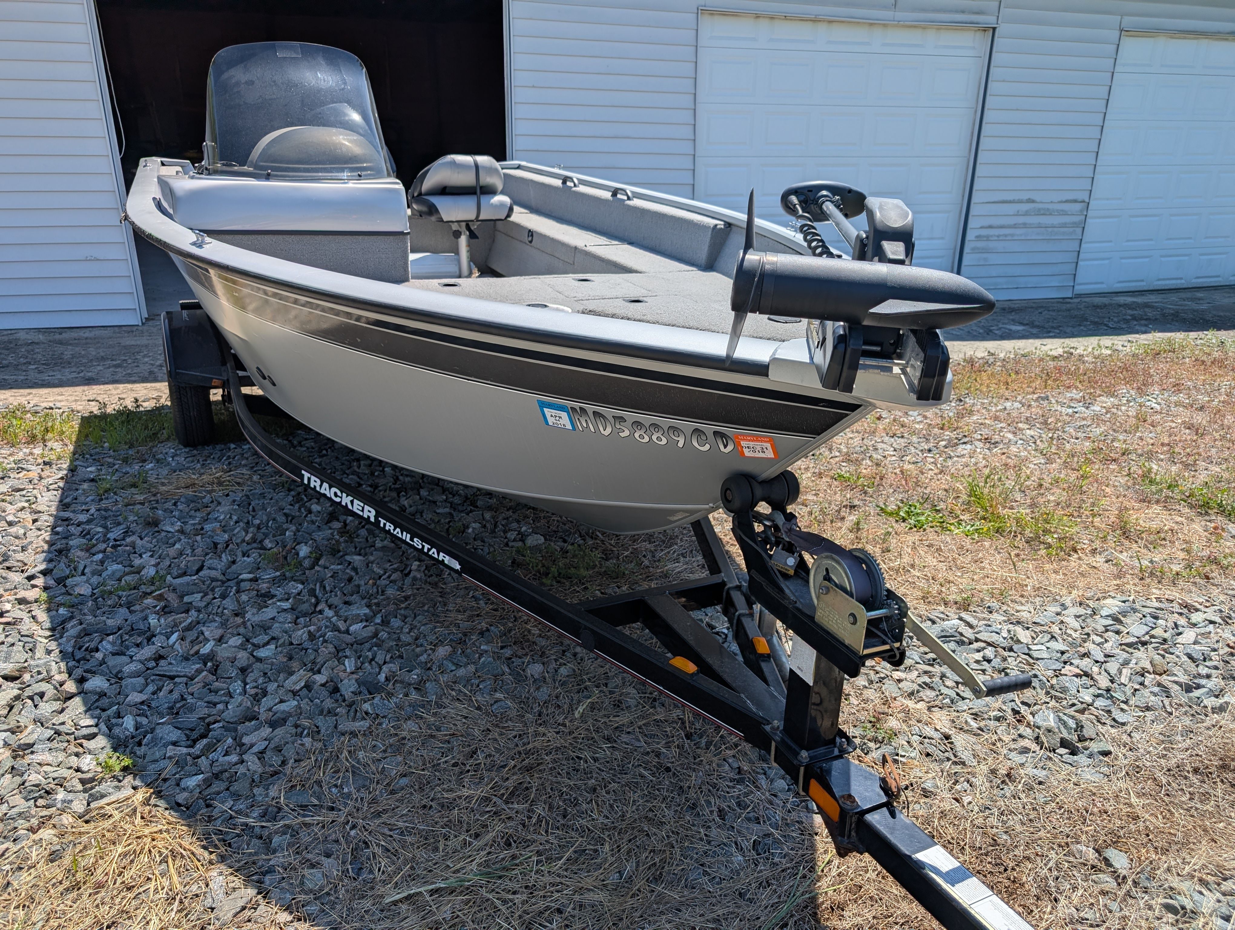 2009 Tracker Pro Guide V16 SE boat on trailer in front of garage.