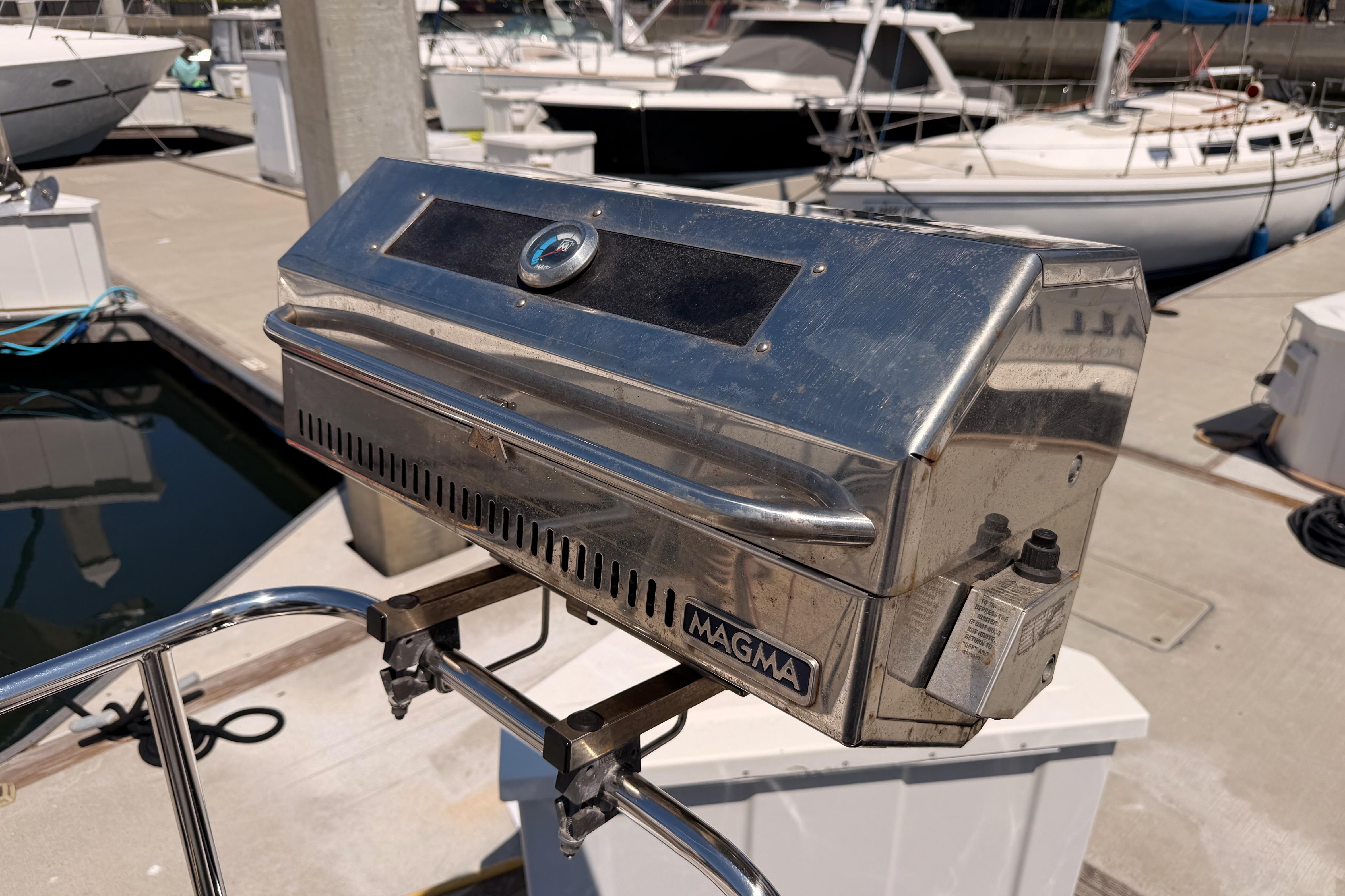 Stainless steel Magma grill on a 2022 Beneteau Oceanis Yacht 54 at a marina.