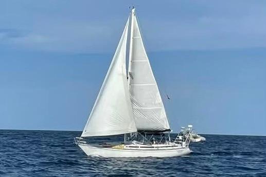 1986 Gulfstar HIRSCH sailboat navigating open sea under clear skies.