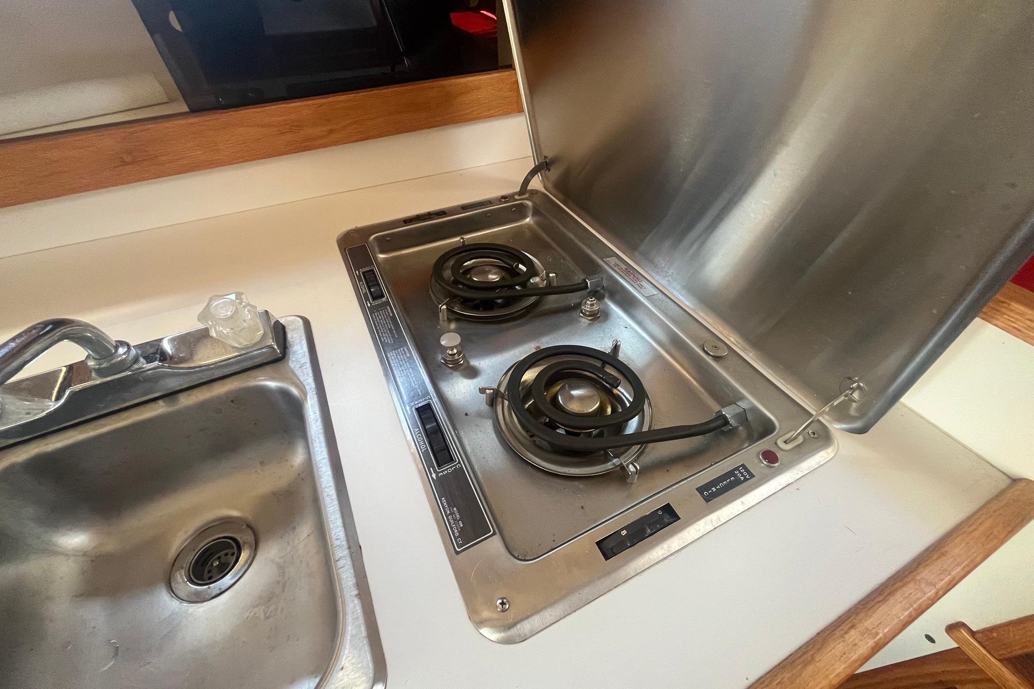 1988 Seafox 29 Flybridge kitchen with stainless steel sink and dual-burner stove.