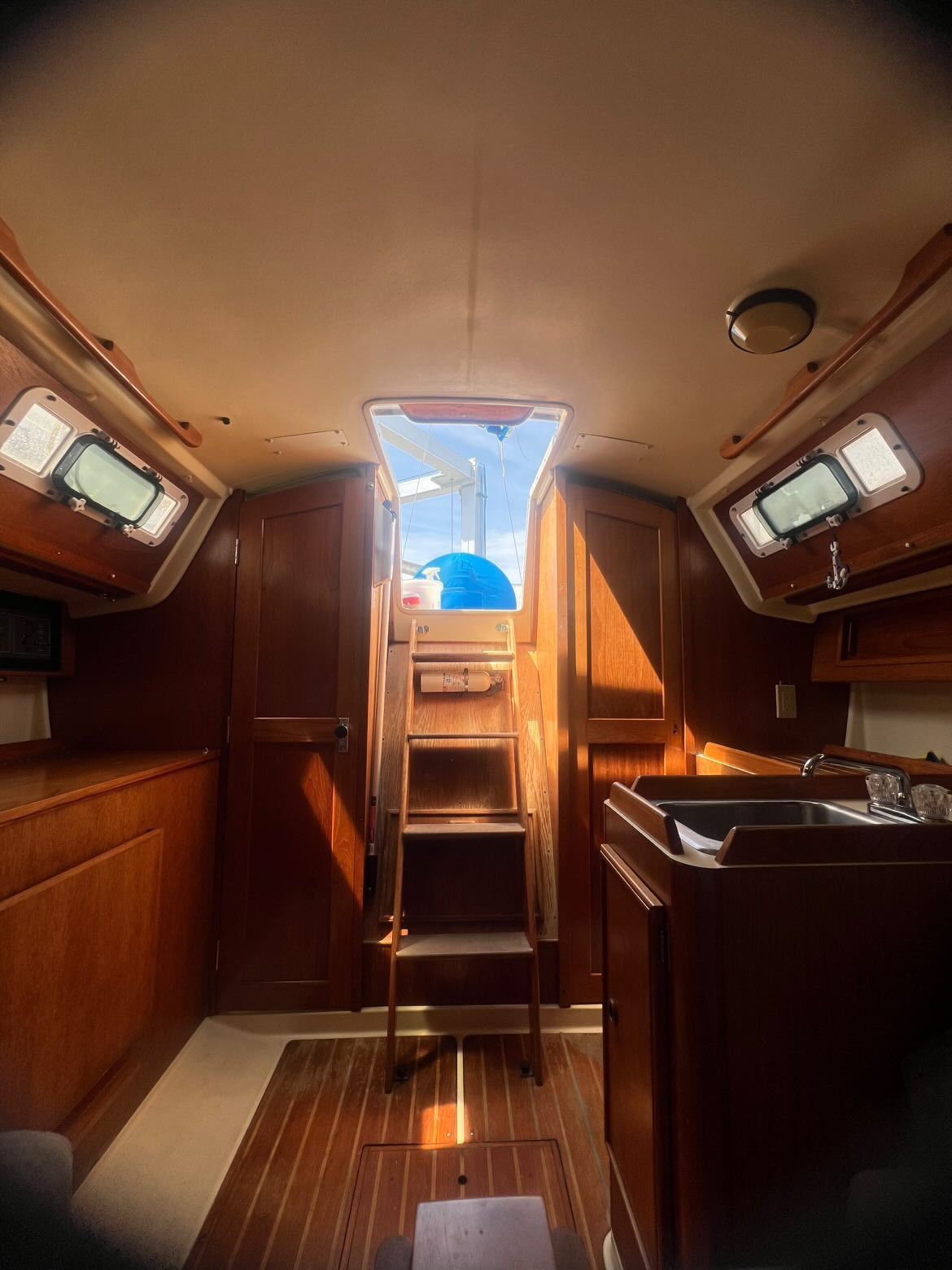 Interior of a 1988 Pearson 28 with wood finish and view outside.