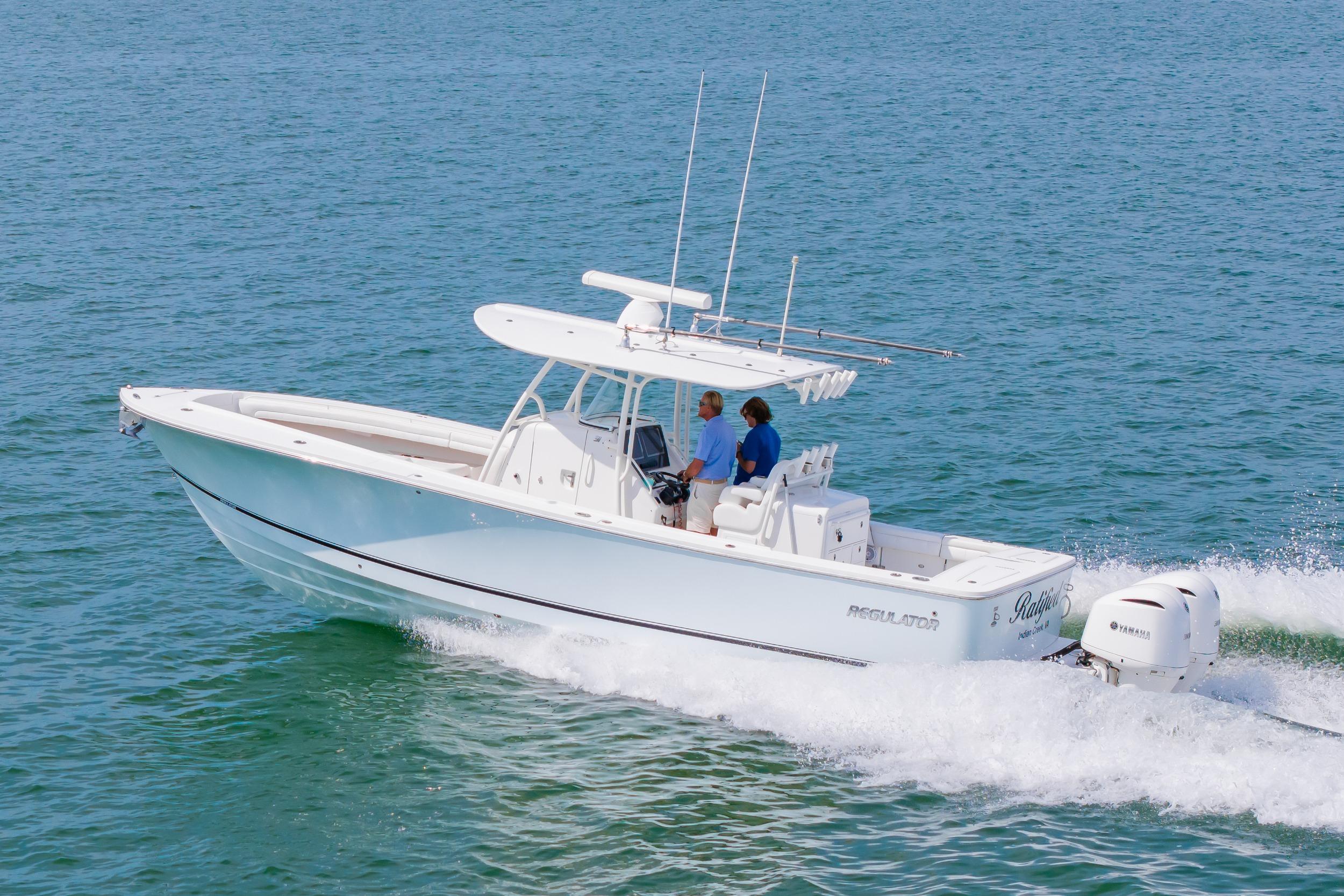 2019 Regulator 31 boat cruising on open water with two people onboard.