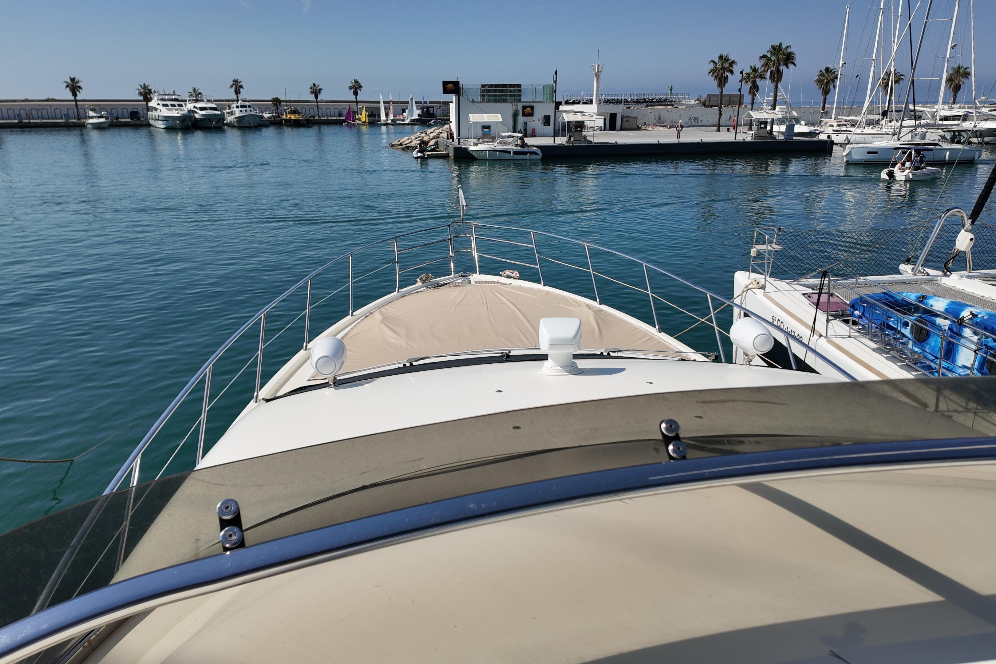 Bow view of 2006 Azimut 68E yacht docked in a sunny marina.