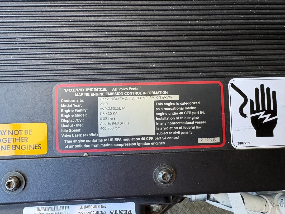 Volvo Penta engine with emission information and warning labels on a black background.