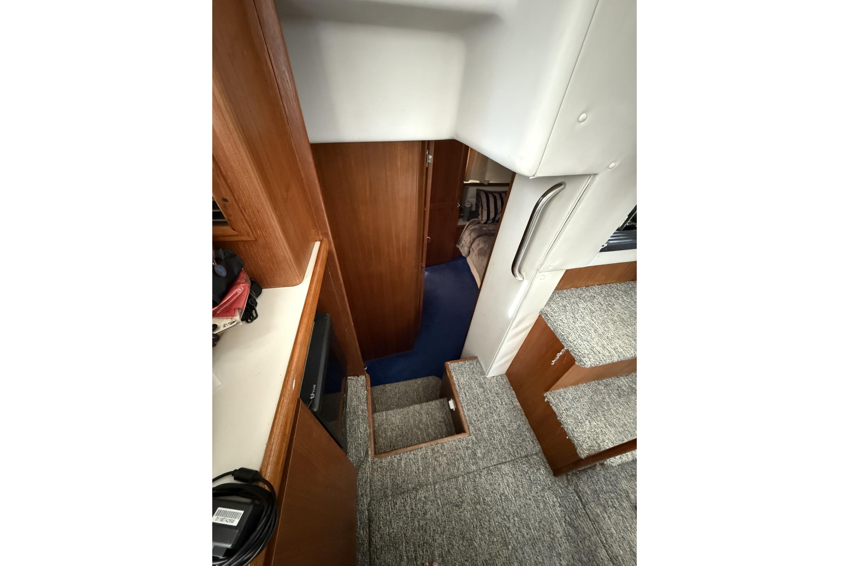 Interior view of 1993 Carver 350 Motor Yacht, featuring carpeted stairs and wooden cabinetry.