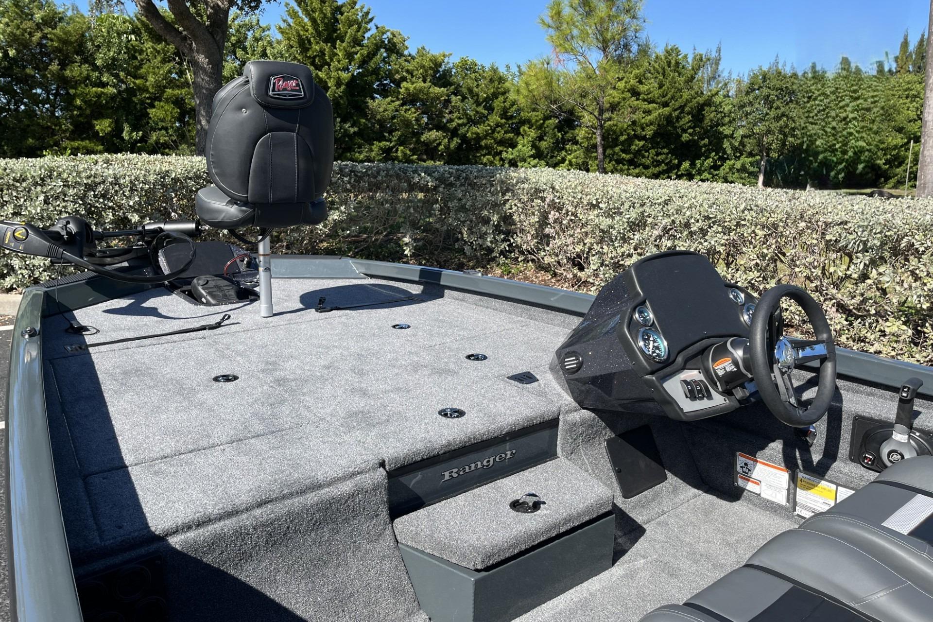 2026 Ranger RT188P boat interior with steering console and seating, surrounded by lush greenery.