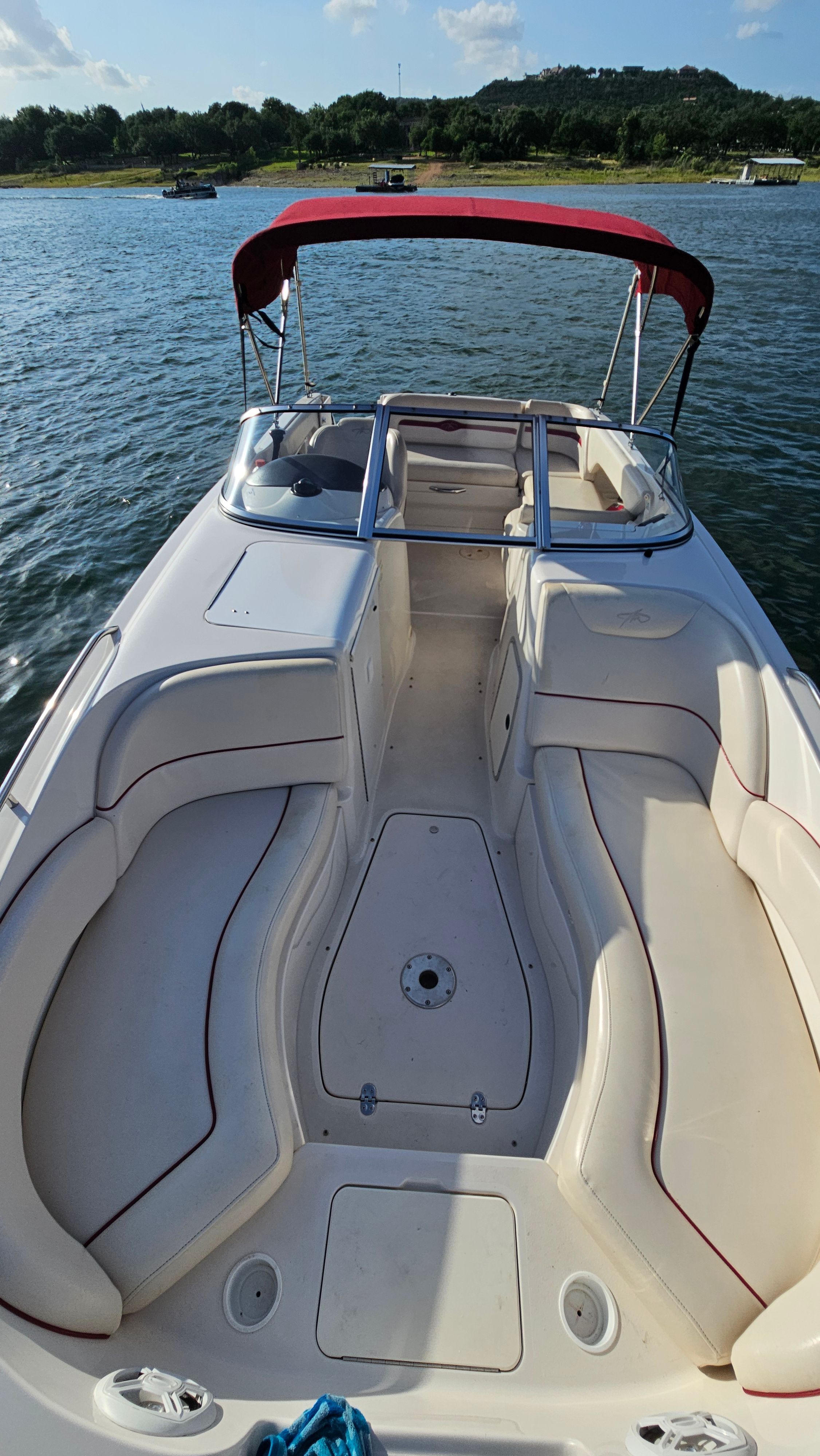 A 2002 Monterey 220 Explorer Sport boat with a red canopy on the water.