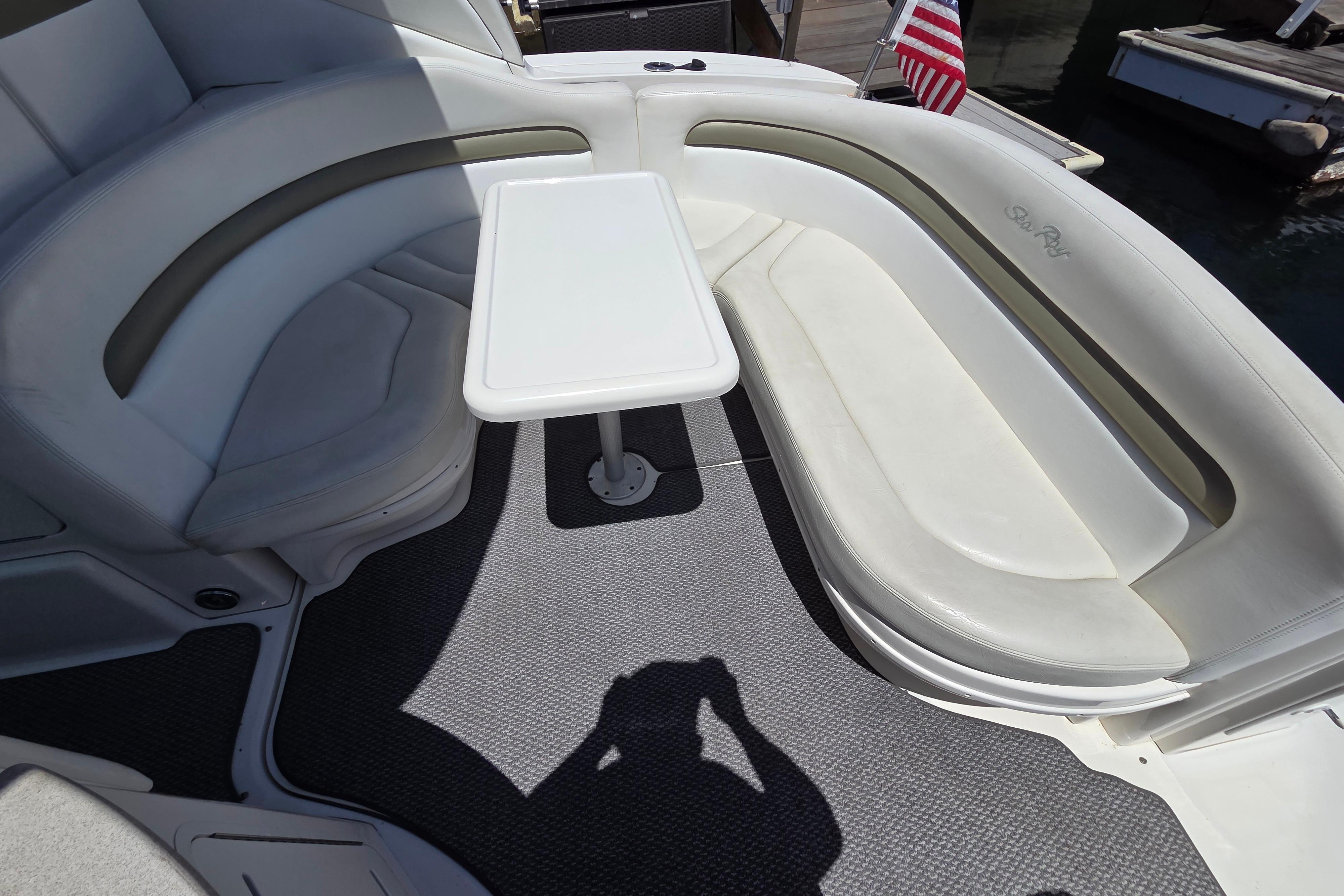 2006 Sea Ray Sundancer 320 boat interior with white seating and small table.