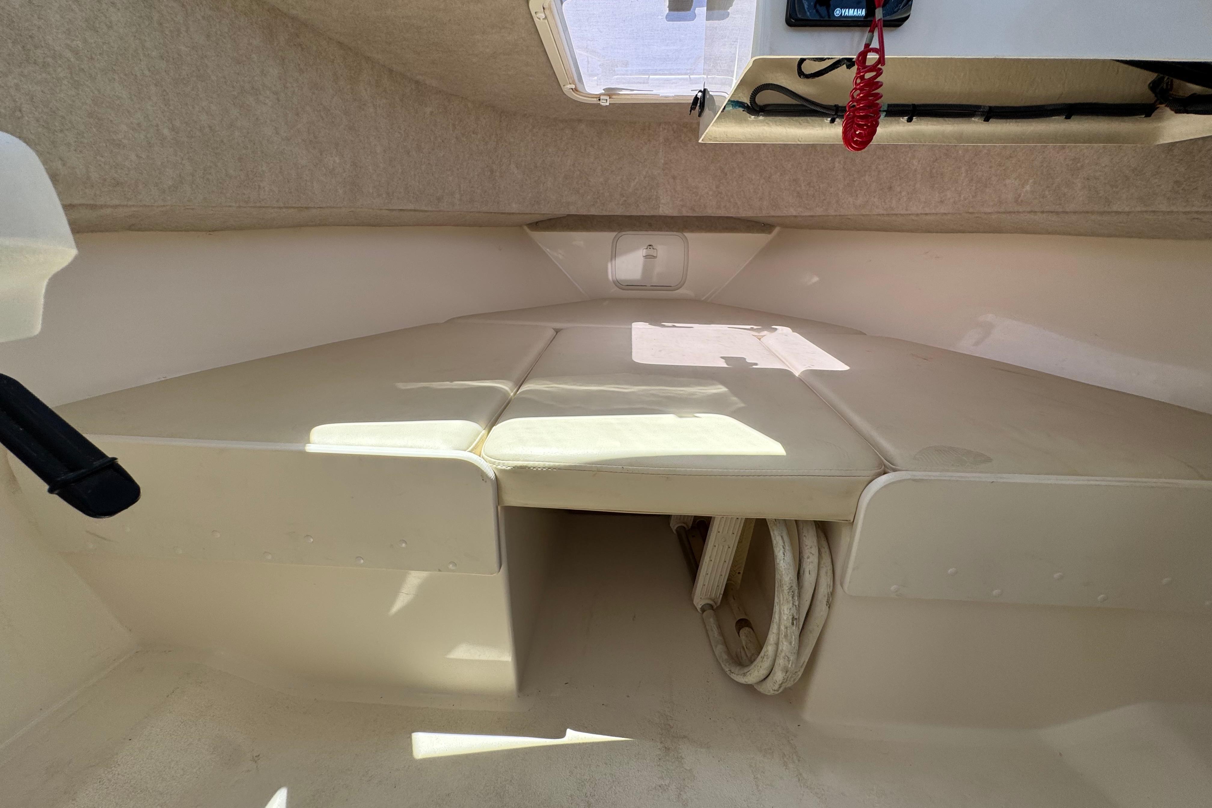 Interior cabin of 2017 Defiance Admiral 220 EX boat, featuring cushioned seating and storage space.