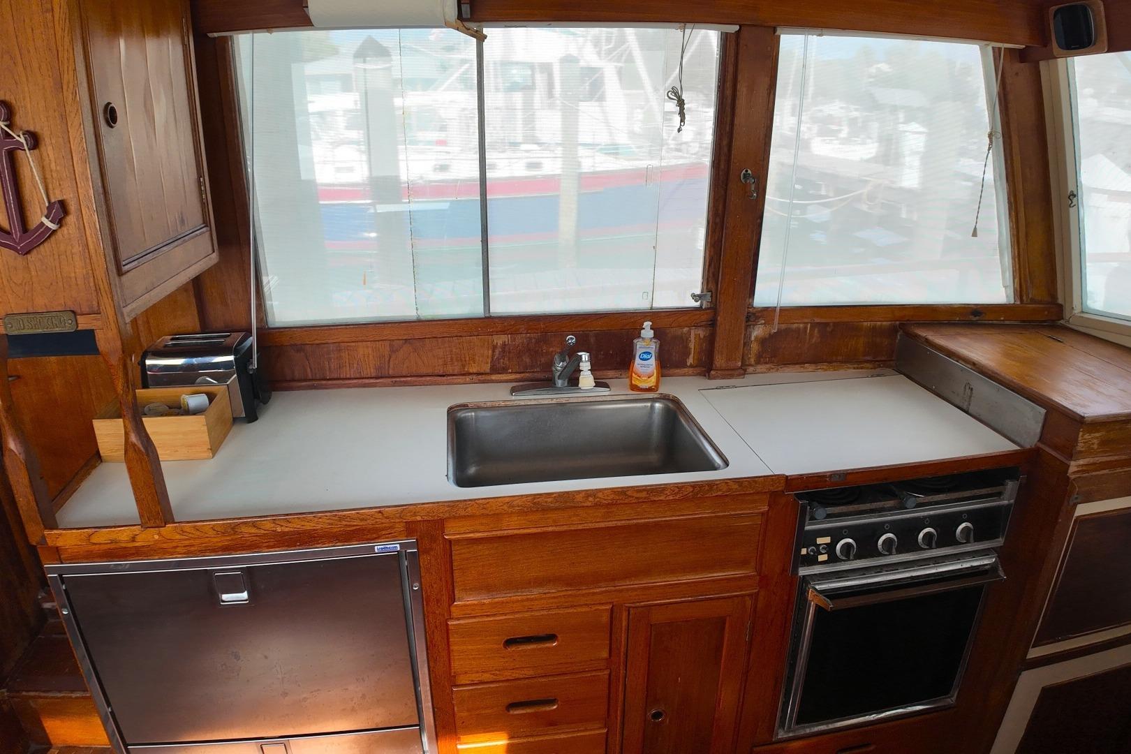 1978 Grand Banks 42 Classic yacht kitchen with wooden cabinetry and stainless steel sink.