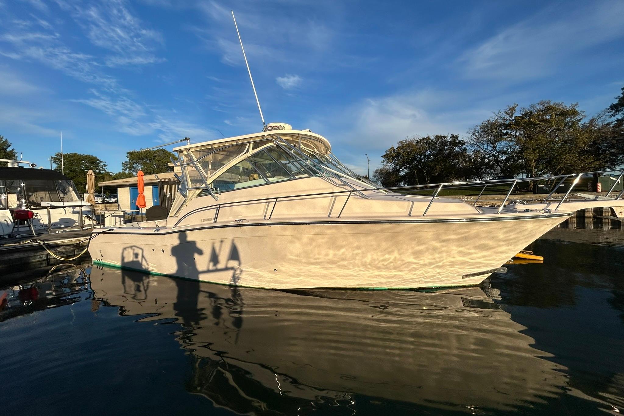 2007 Grady-White Express 360 boat docked on calm water under a clear blue sky.