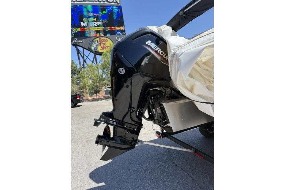 2026 Sun Tracker Party Barge 18 DLX with Mercury outboard motor in parking lot.