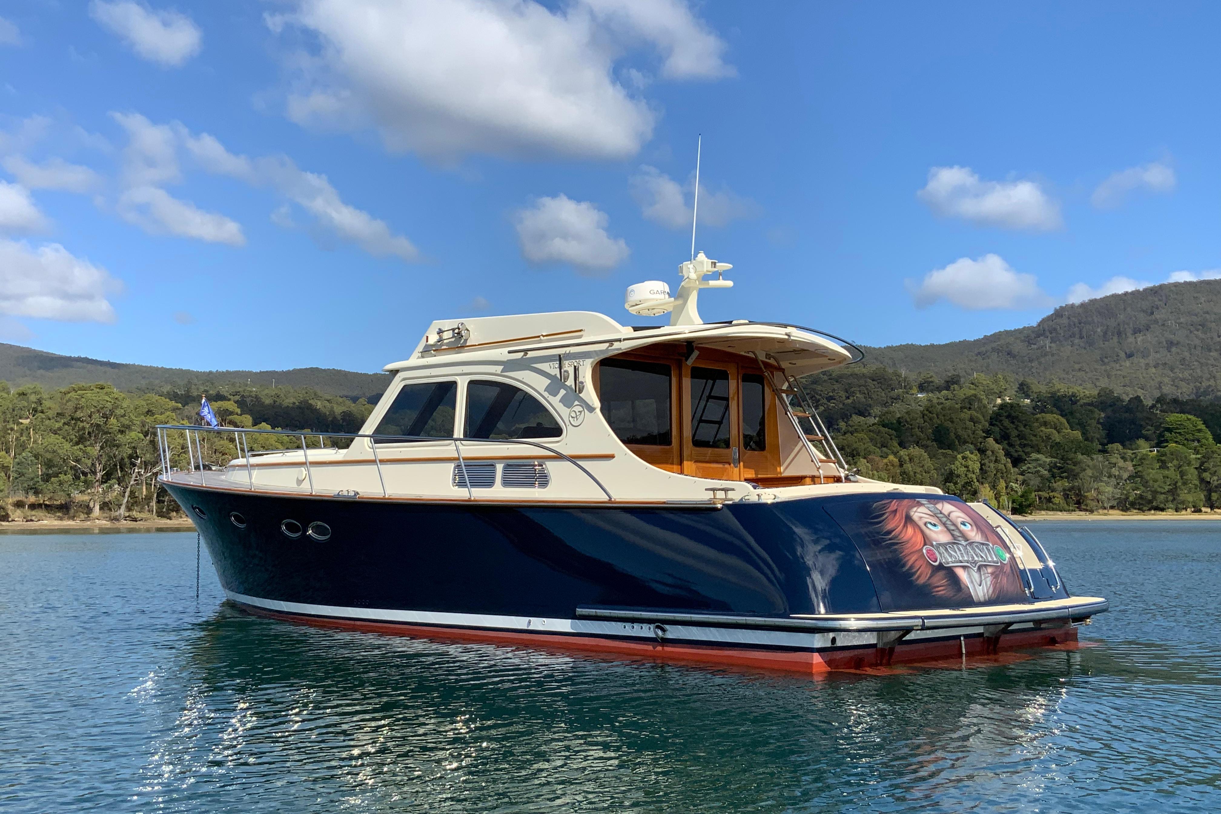 2008 Vicem 44 yacht on serene water with scenic forest backdrop.