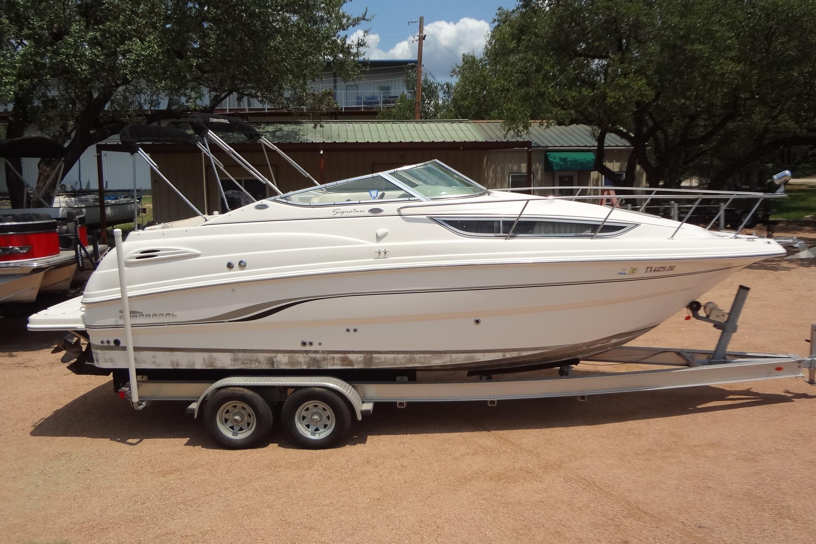 2000 Chaparral Signature 260 boat on trailer, parked outdoors, side view.