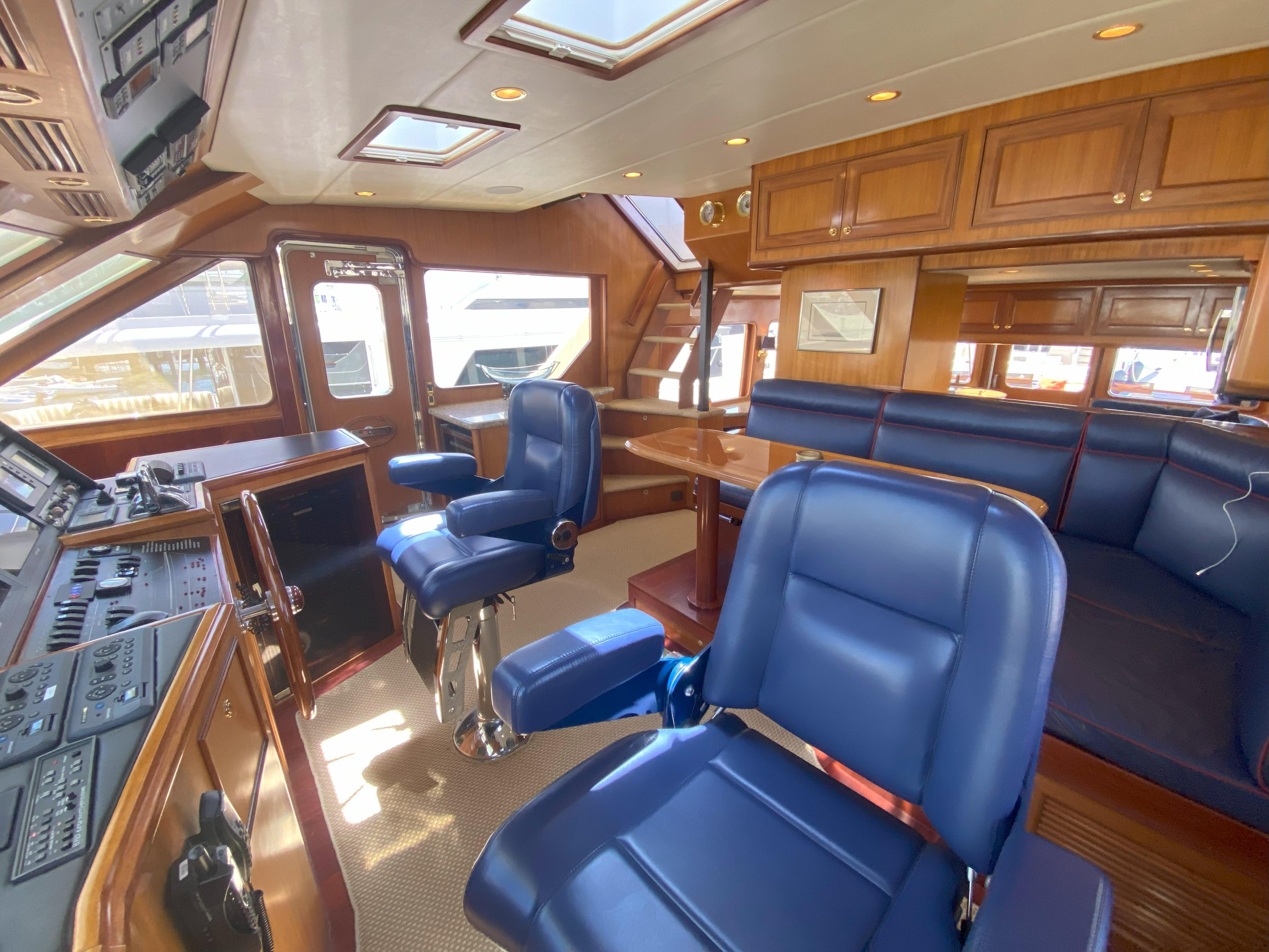 Luxurious interior of a 2005 Offshore Yachts 72' with blue seating and wood finishes.
