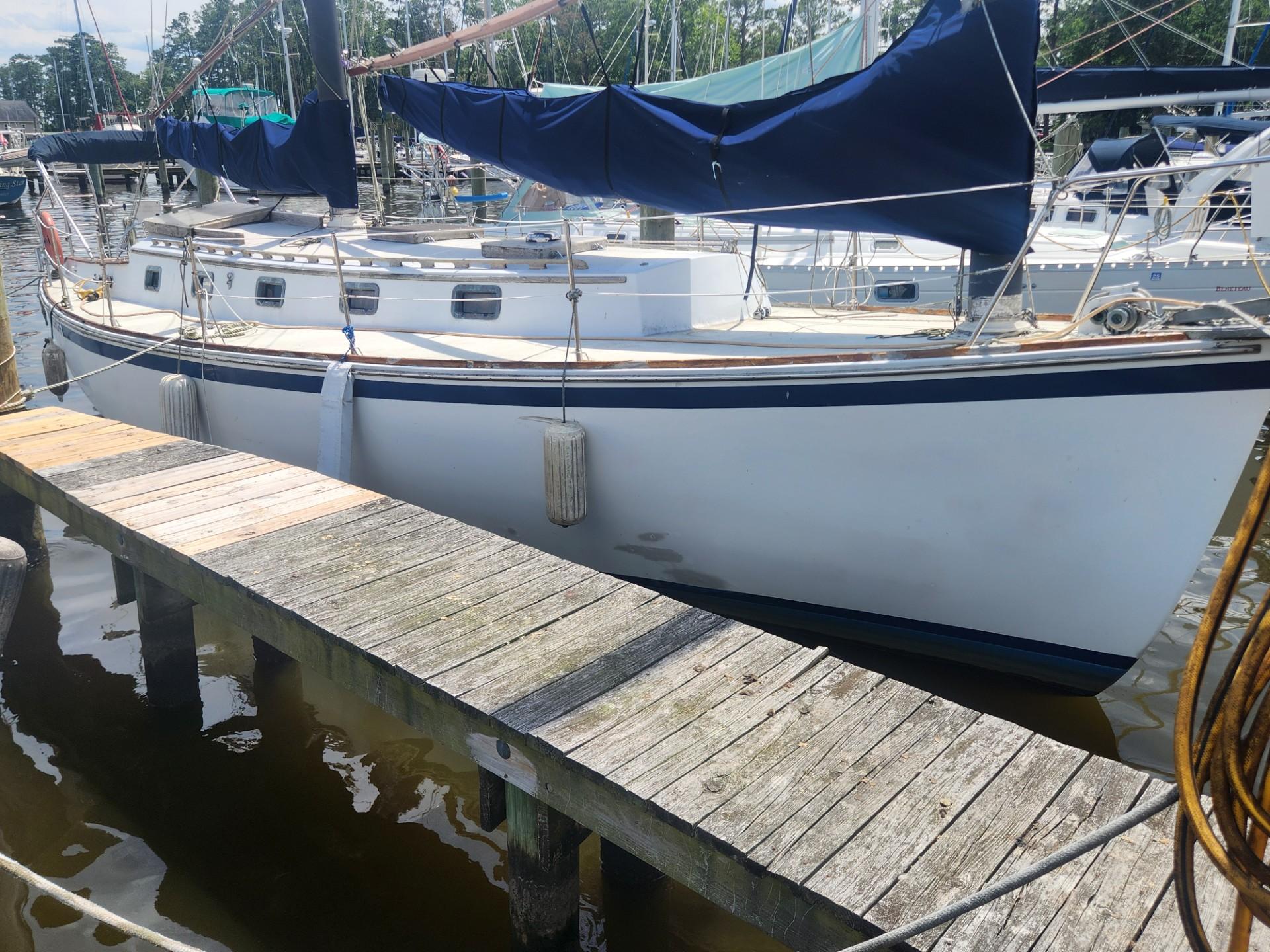 1985 Herreshoff 38 Cat Ketch sailboat docked at a marina.