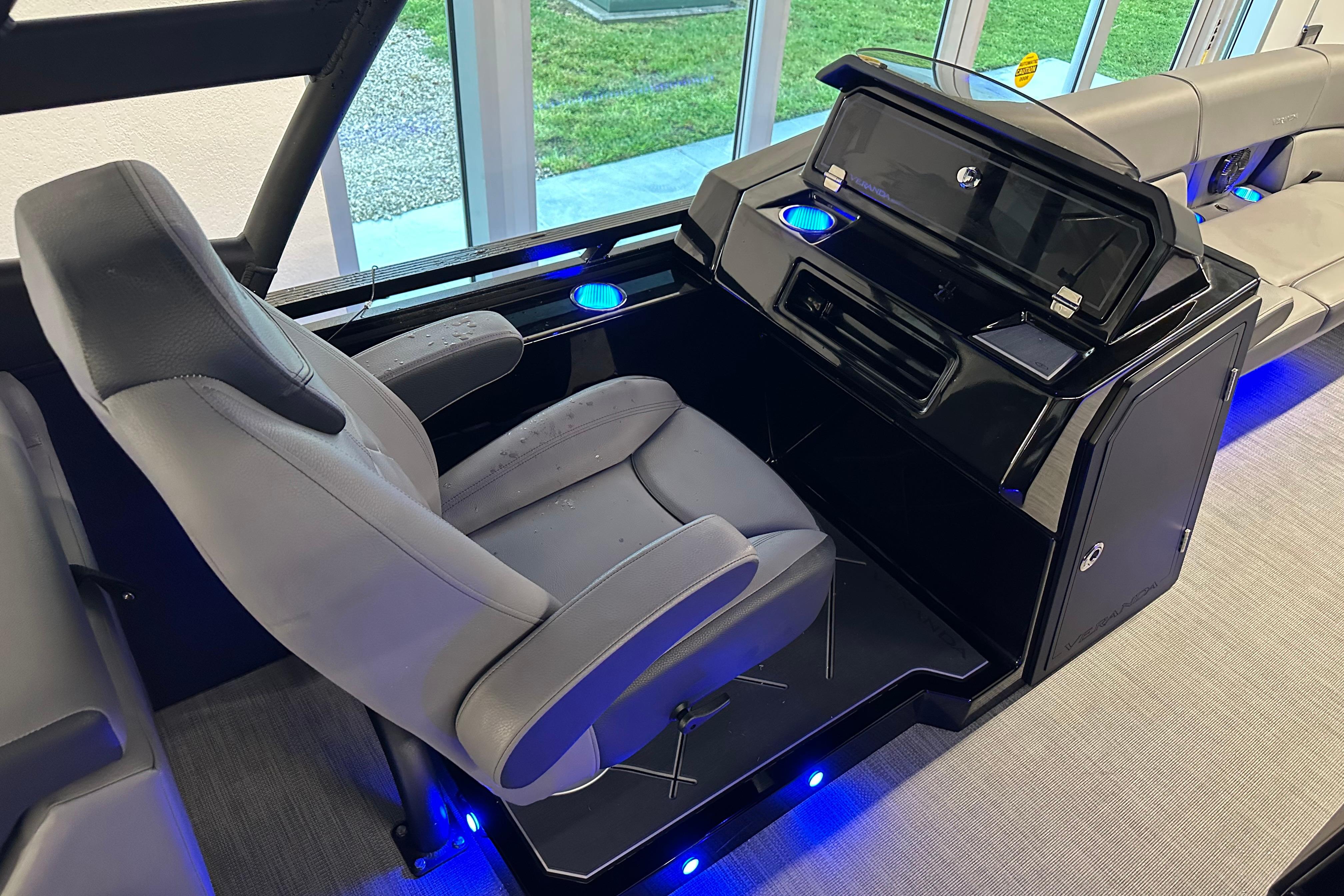 Captain's chair and console of 2025 Veranda VX 27 DCRC boat with blue LED lighting.
