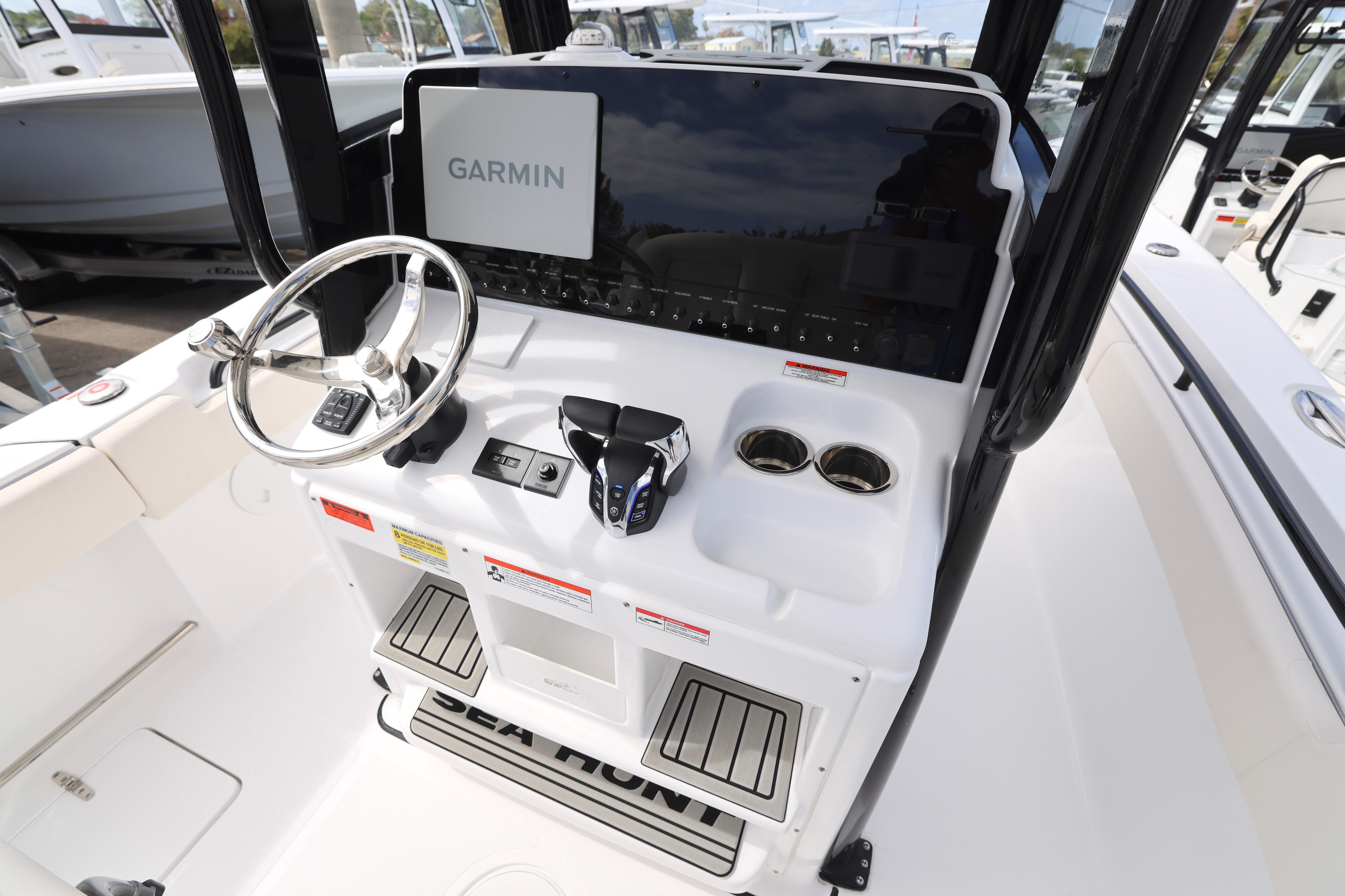 2026 Sea Hunt Gamefish 25 boat console with Garmin display and steering wheel.