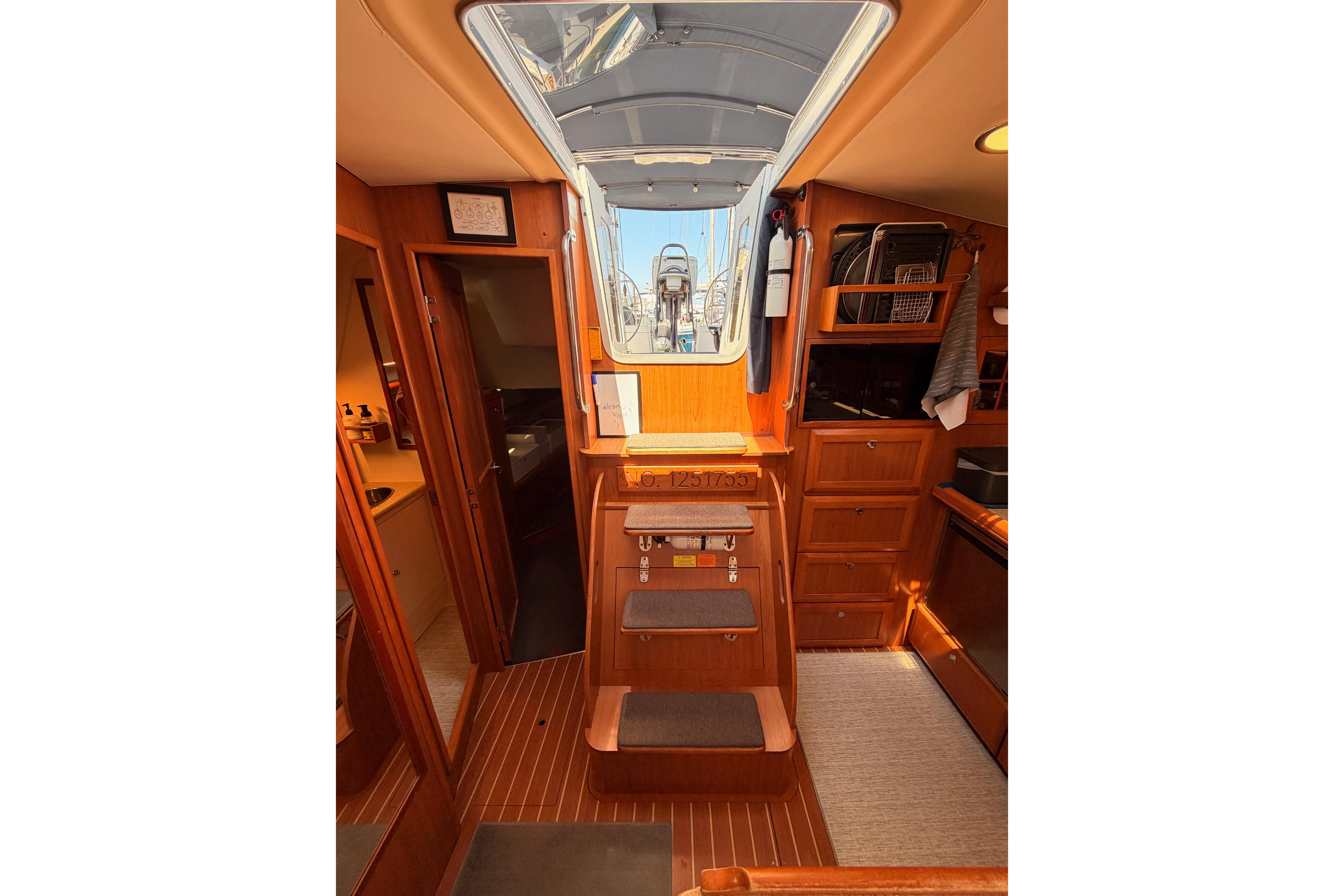 Interior of 2008 Hunter 45 Deck Salon yacht with wooden cabinetry and steps.