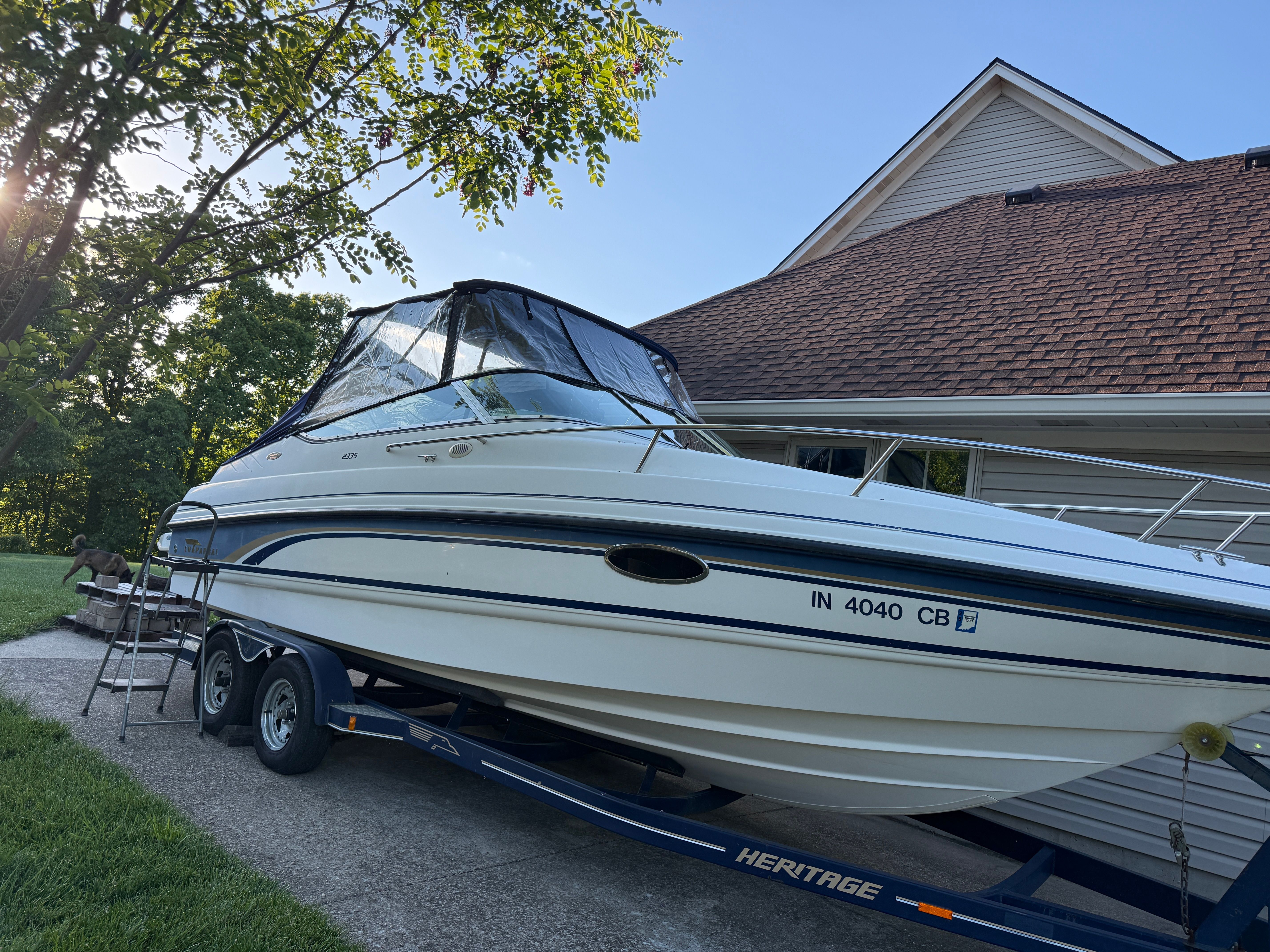 1999 Custom 2335 Cuddy cabin boat on trailer by garage.