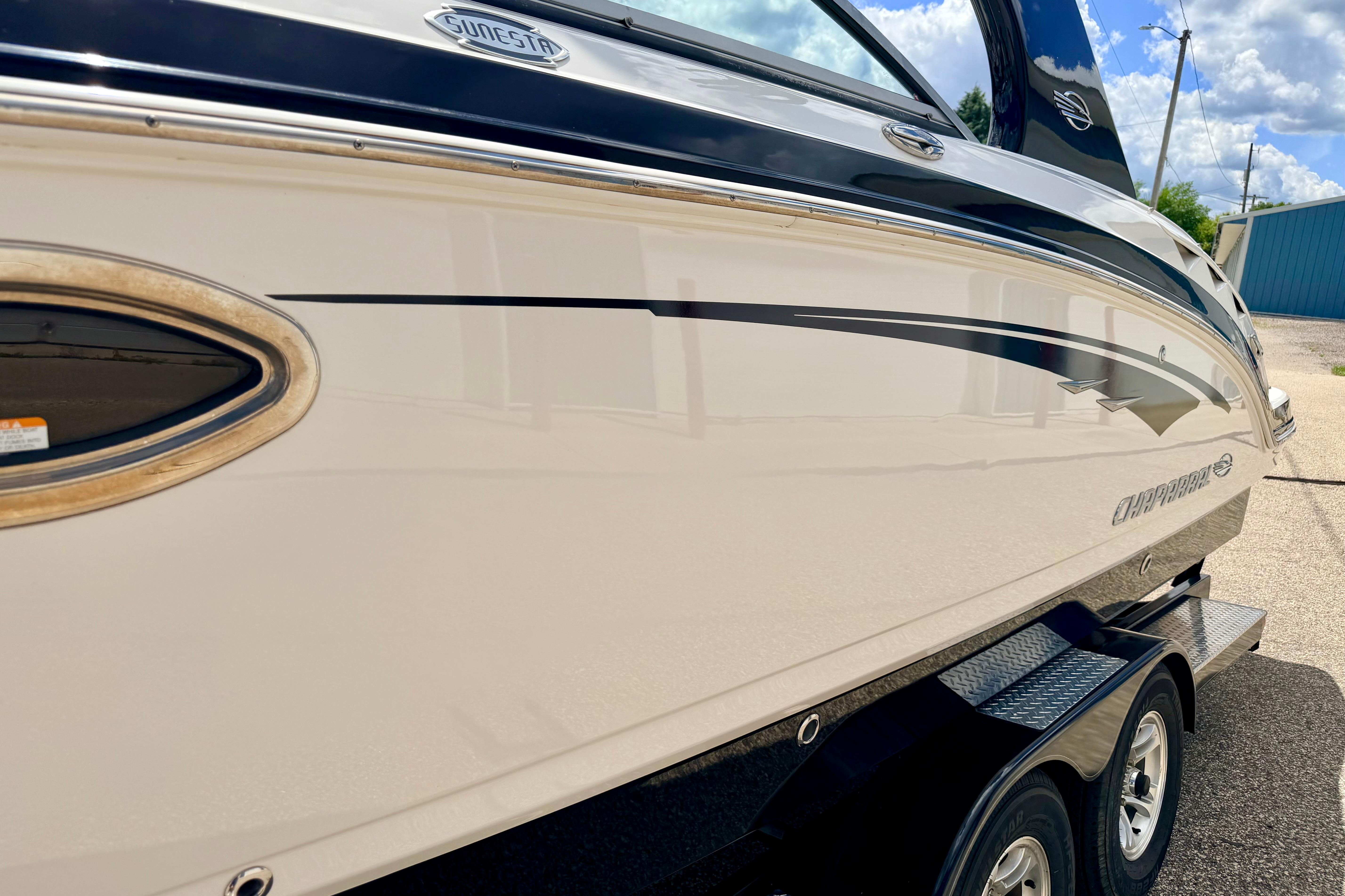 2015 Chaparral Sunesta 264 boat side view with sleek design and trailer.