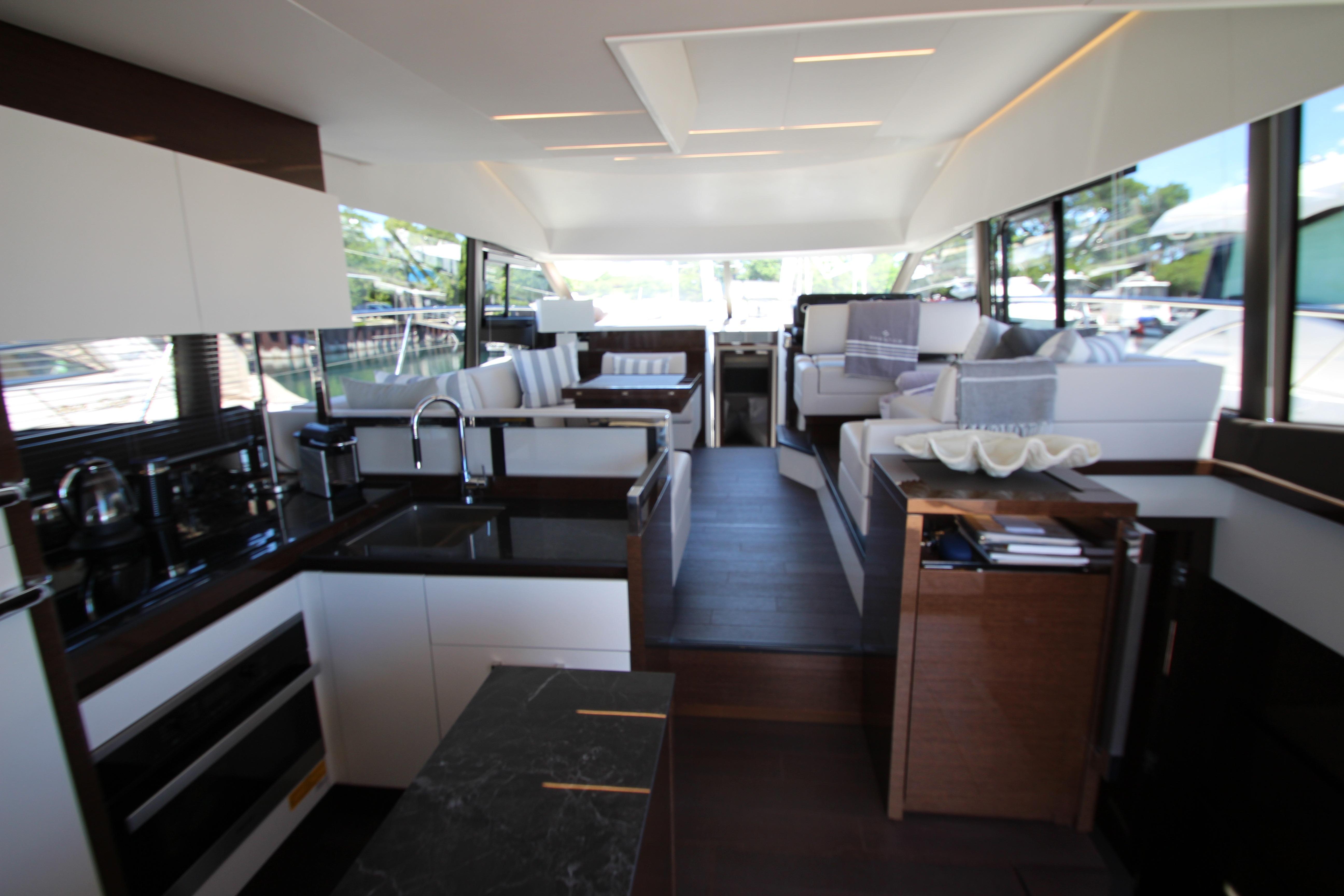 Luxurious interior of 2022 Prestige 520 yacht featuring modern kitchen and elegant seating area.