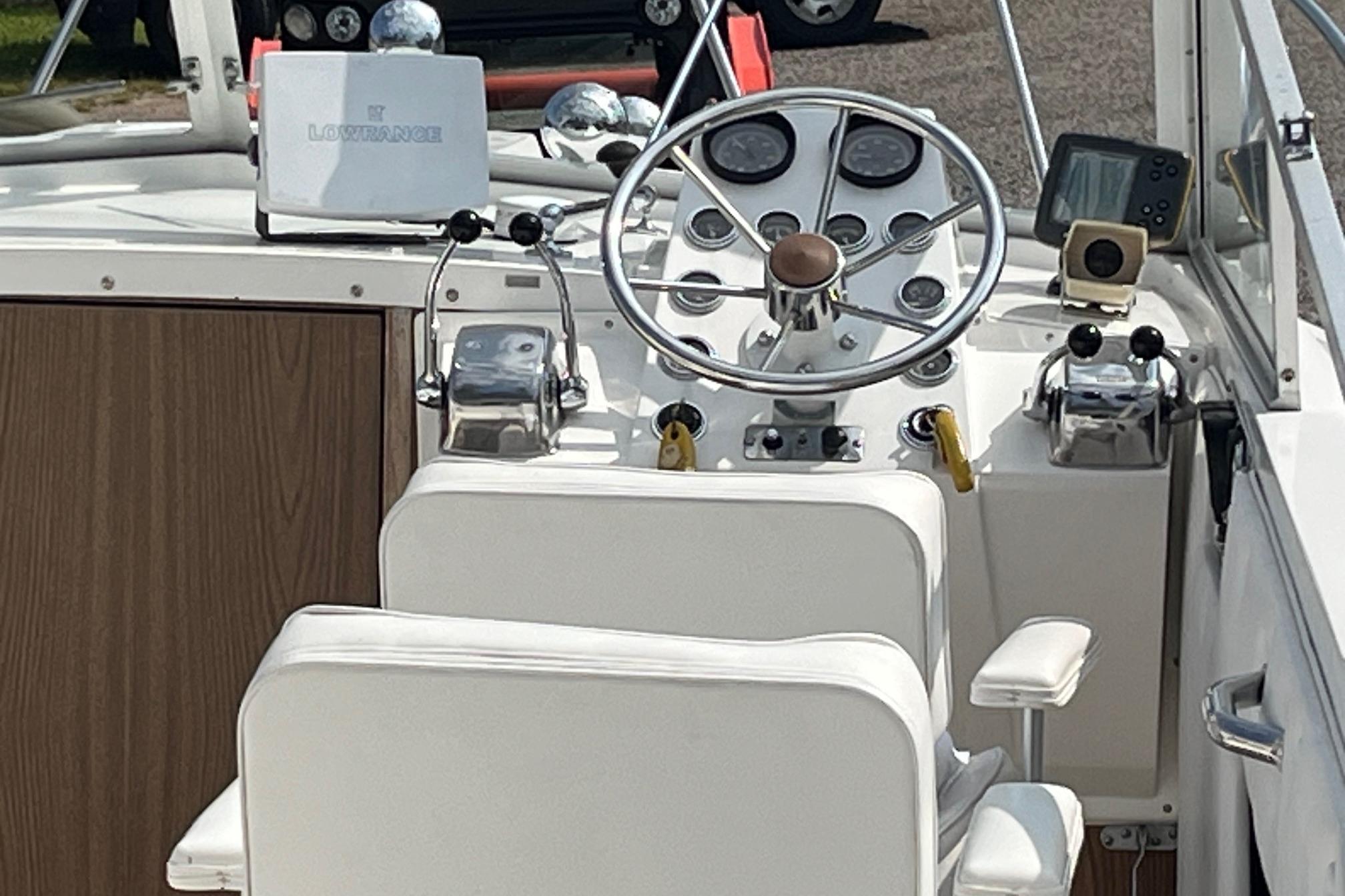 1975 Bertram 26 Moppie boat helm with steering wheel and navigation equipment.