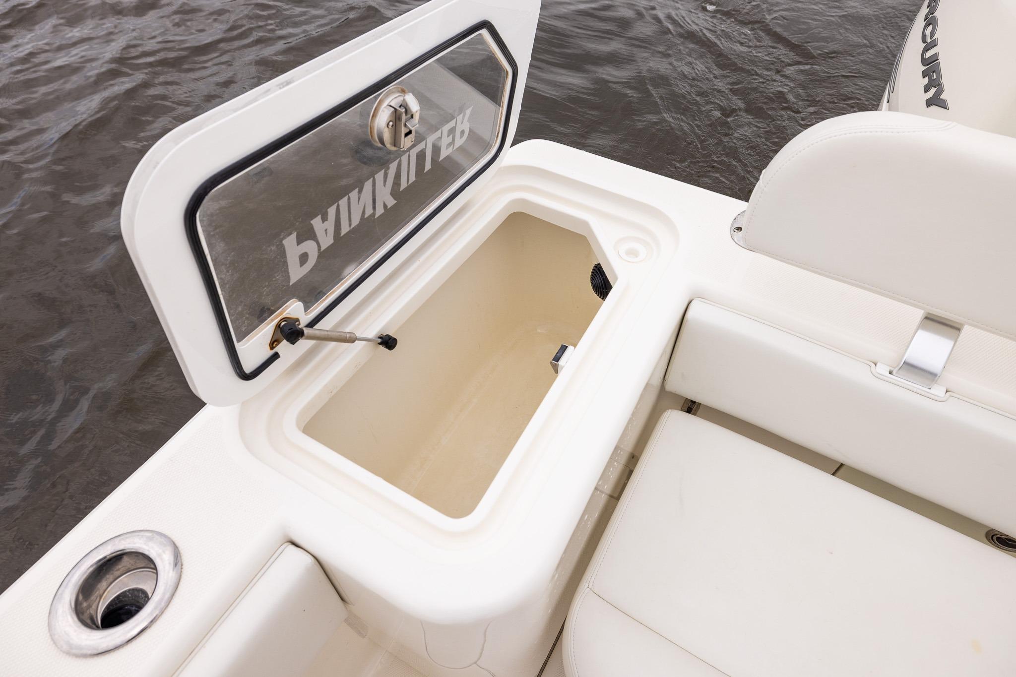 2019 SeaVee 322Z boat with open storage compartment, white seating, and water backdrop.