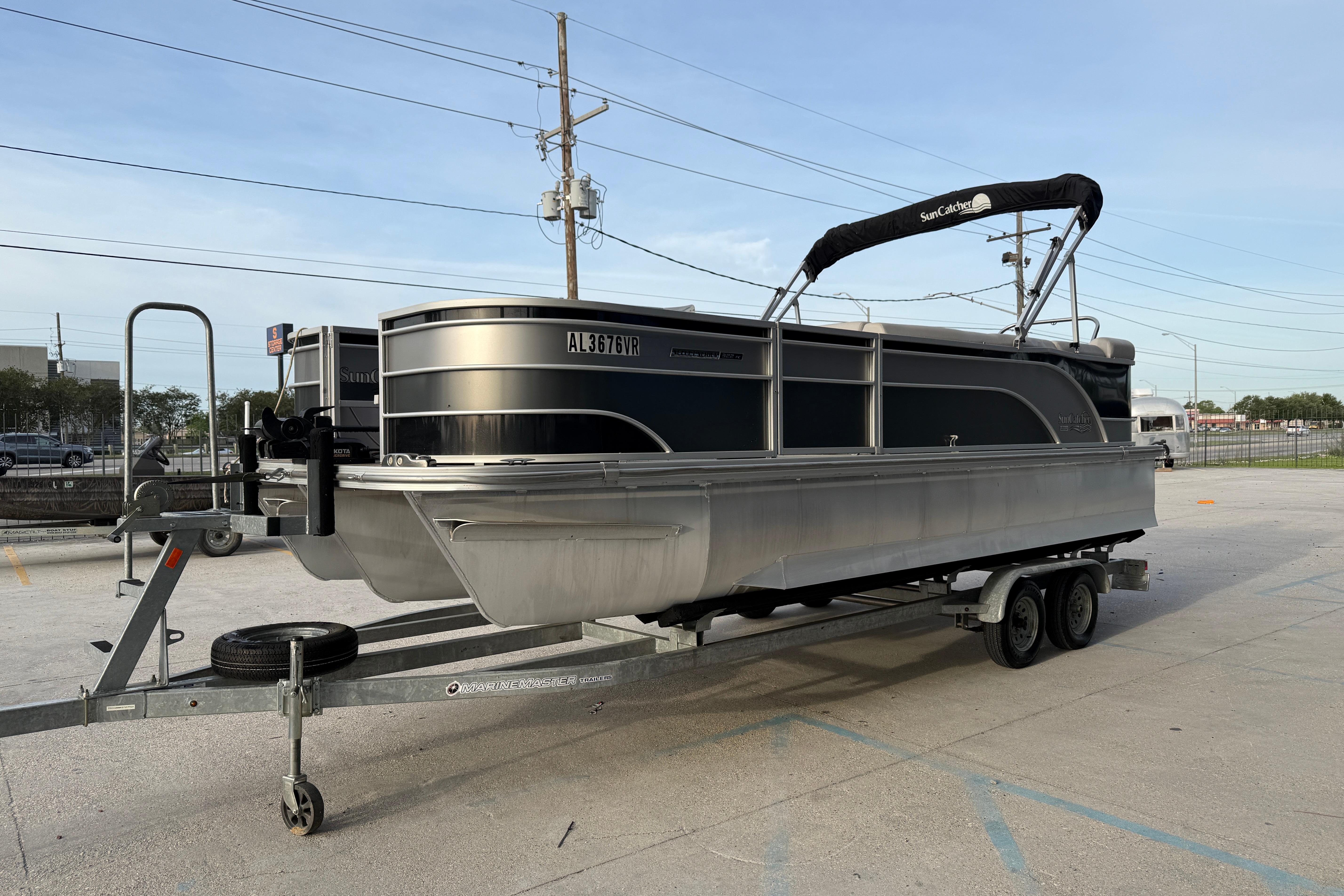 2022 Custom G3 Suncatcher 322FC pontoon boat on trailer in parking lot.