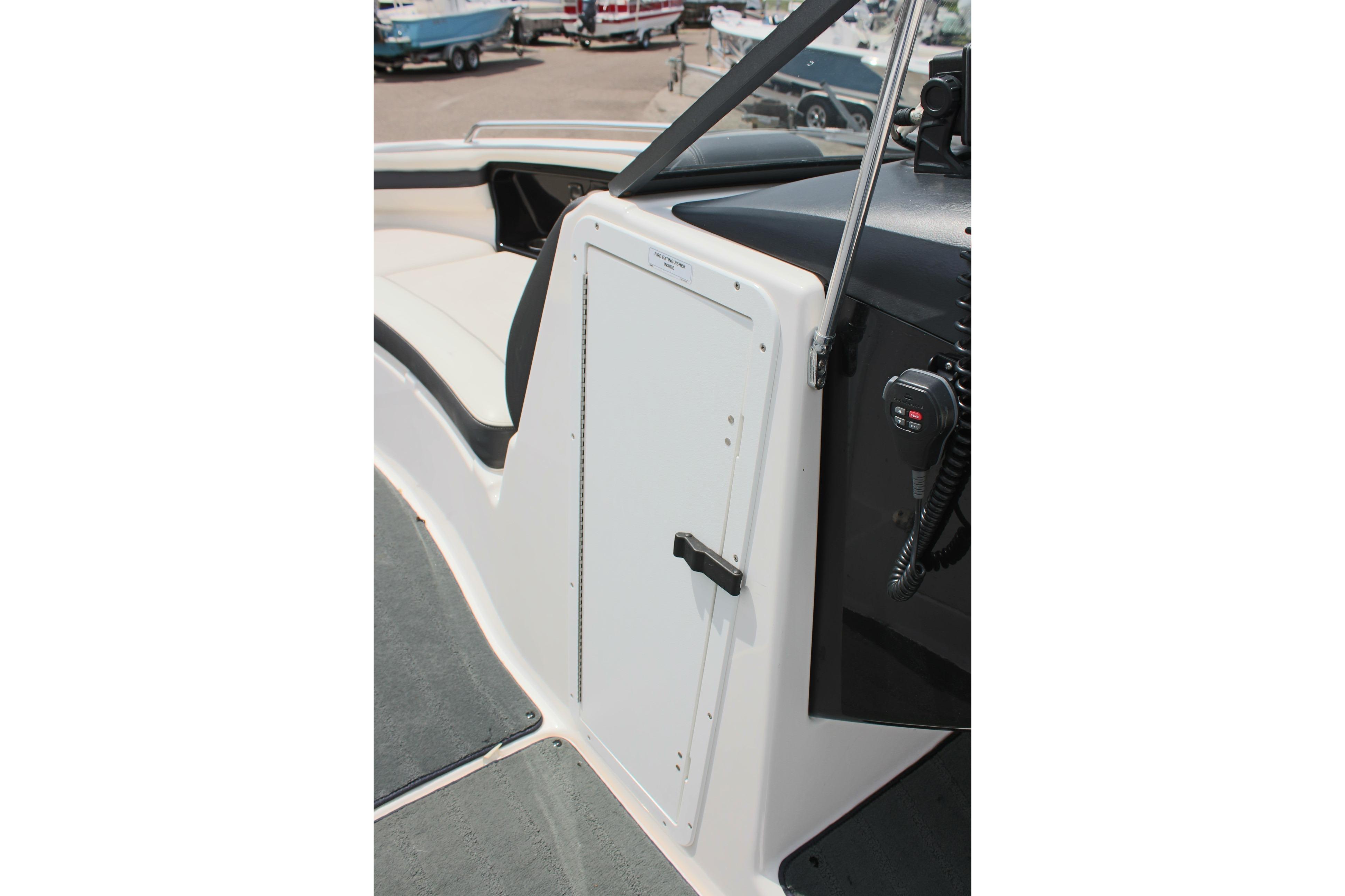 2016 Yamaha Boats 242 Limited S interior with storage compartment and control panel.