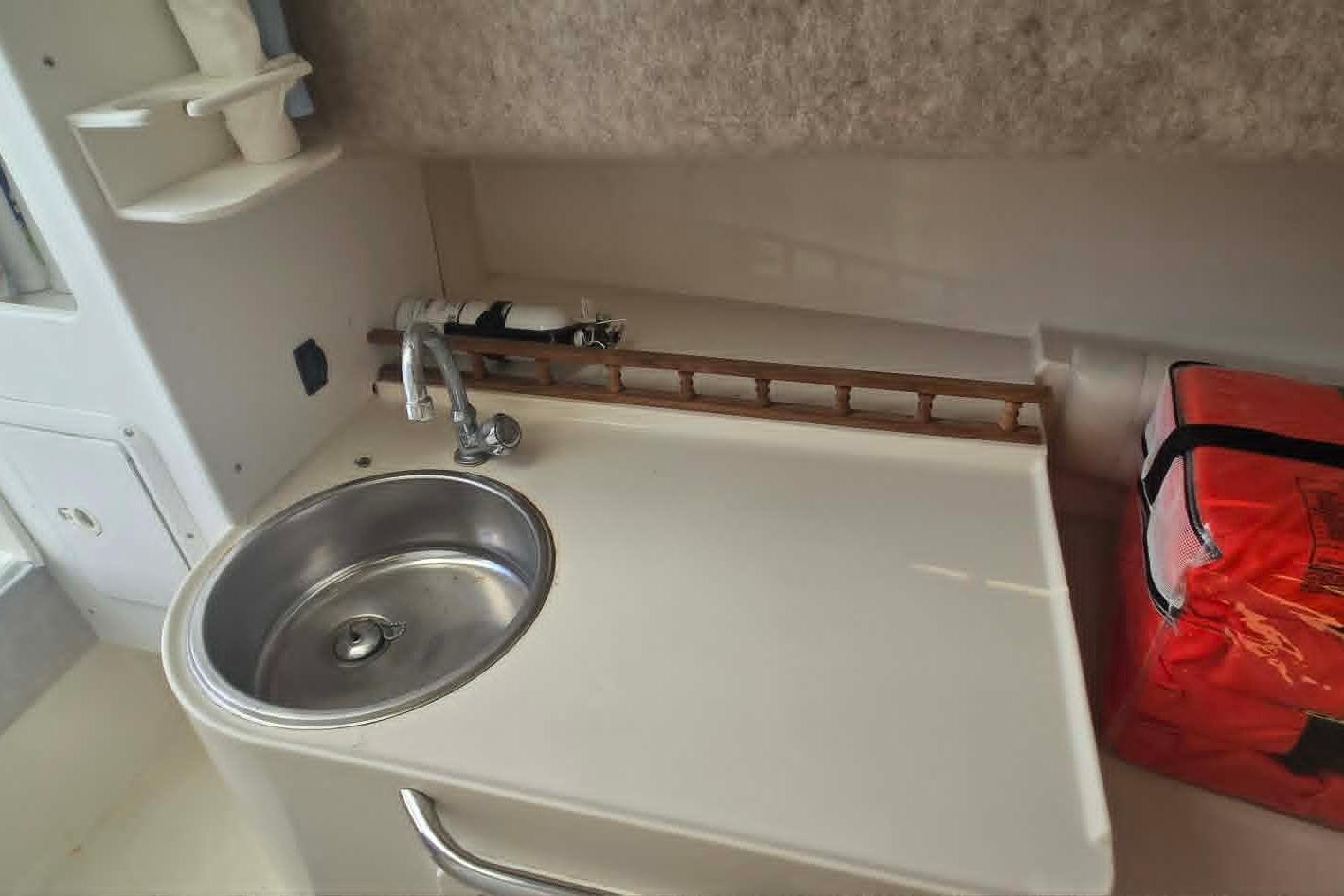 2003 True World Marine 286 boat interior with sink and storage area.
