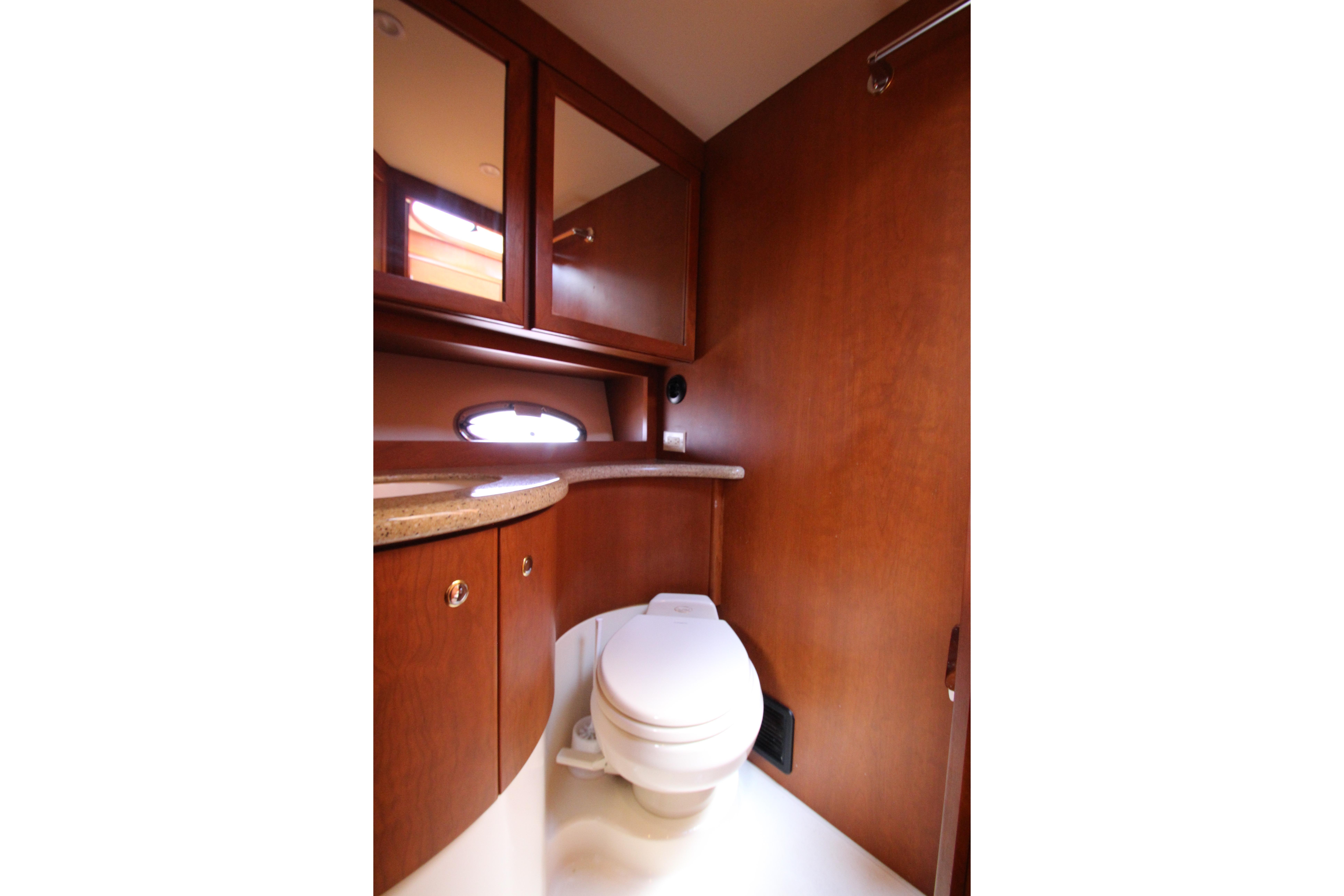 Luxurious bathroom interior of 2006 Silverton 38 Sport Bridge yacht with wooden cabinetry.