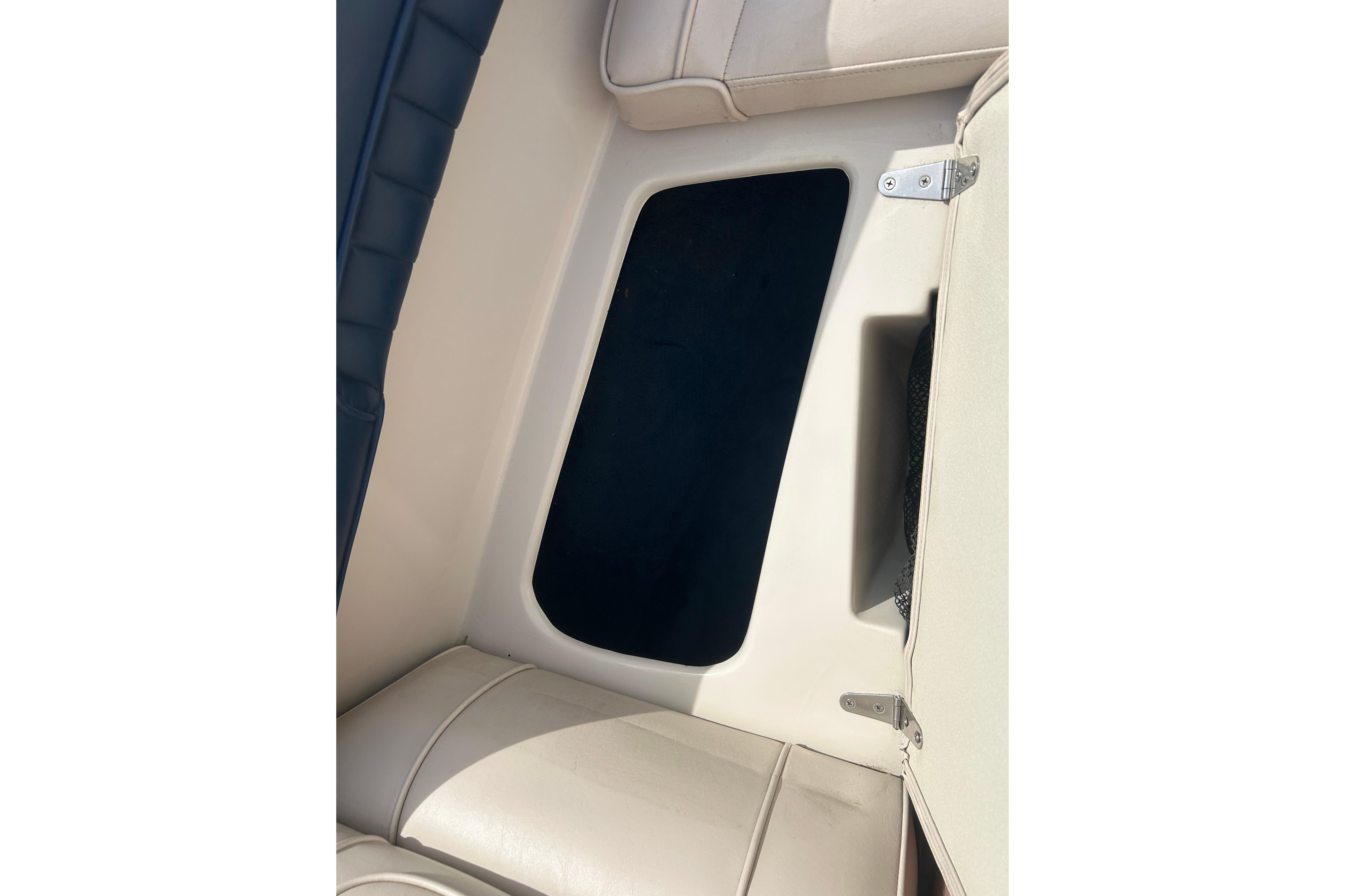 Interior view of a 1996 Mariah 180 Shabah boat, featuring beige seating and storage compartment.