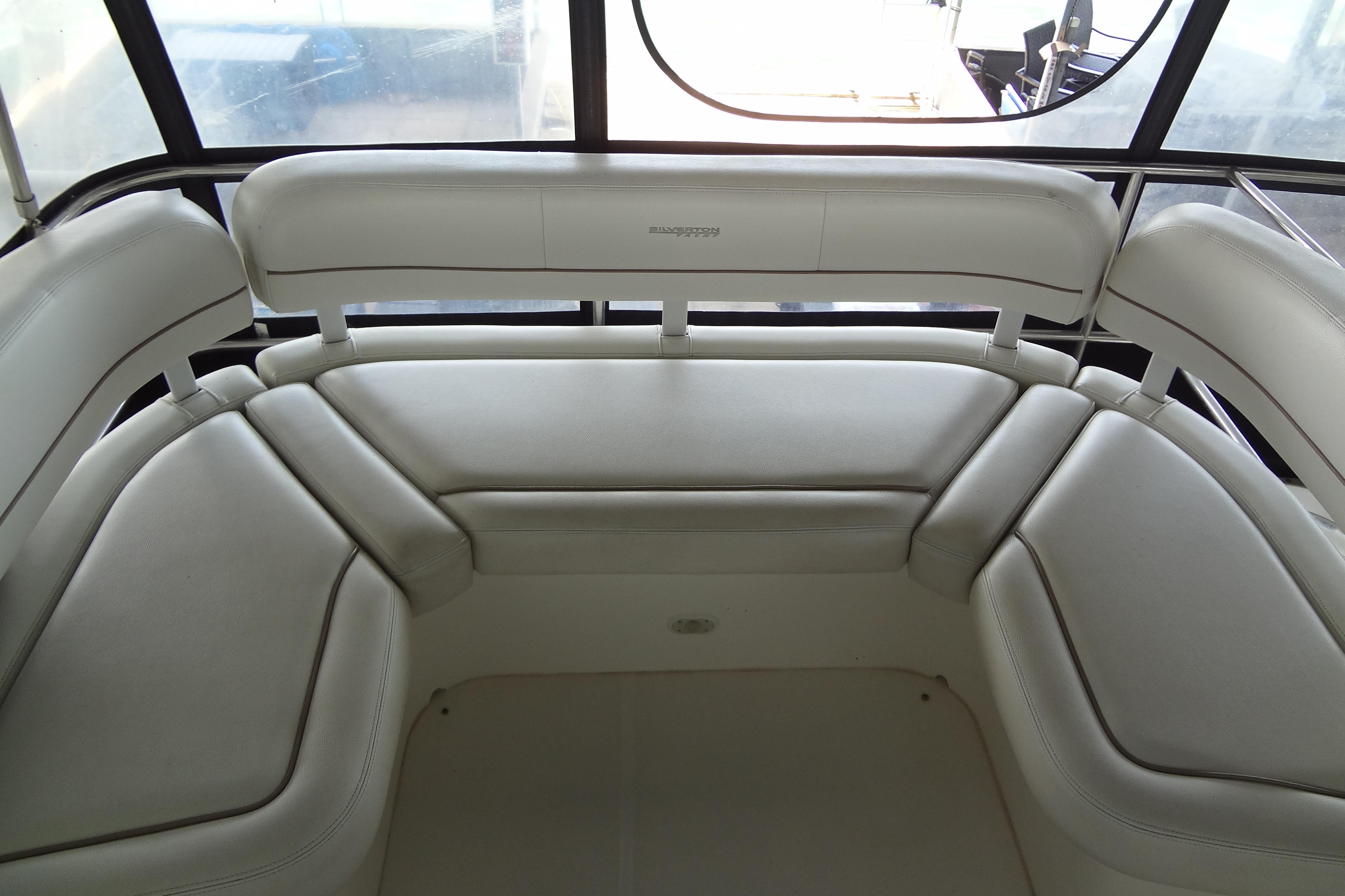 Interior seating of a 2005 Silverton 34 Convertible yacht, featuring white cushioned benches.