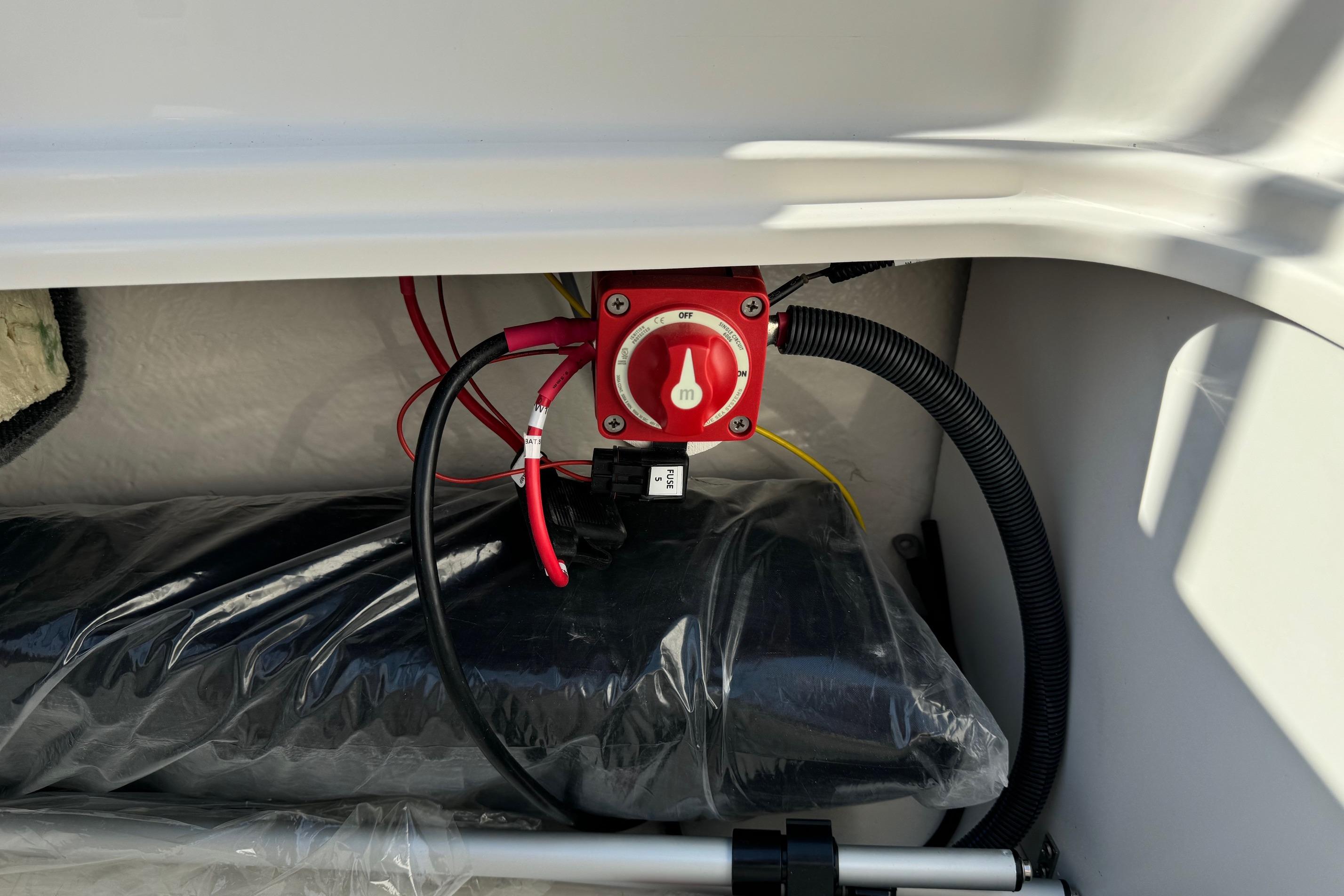 Battery switch and wiring inside 2025 Bayliner Element E16 boat compartment.